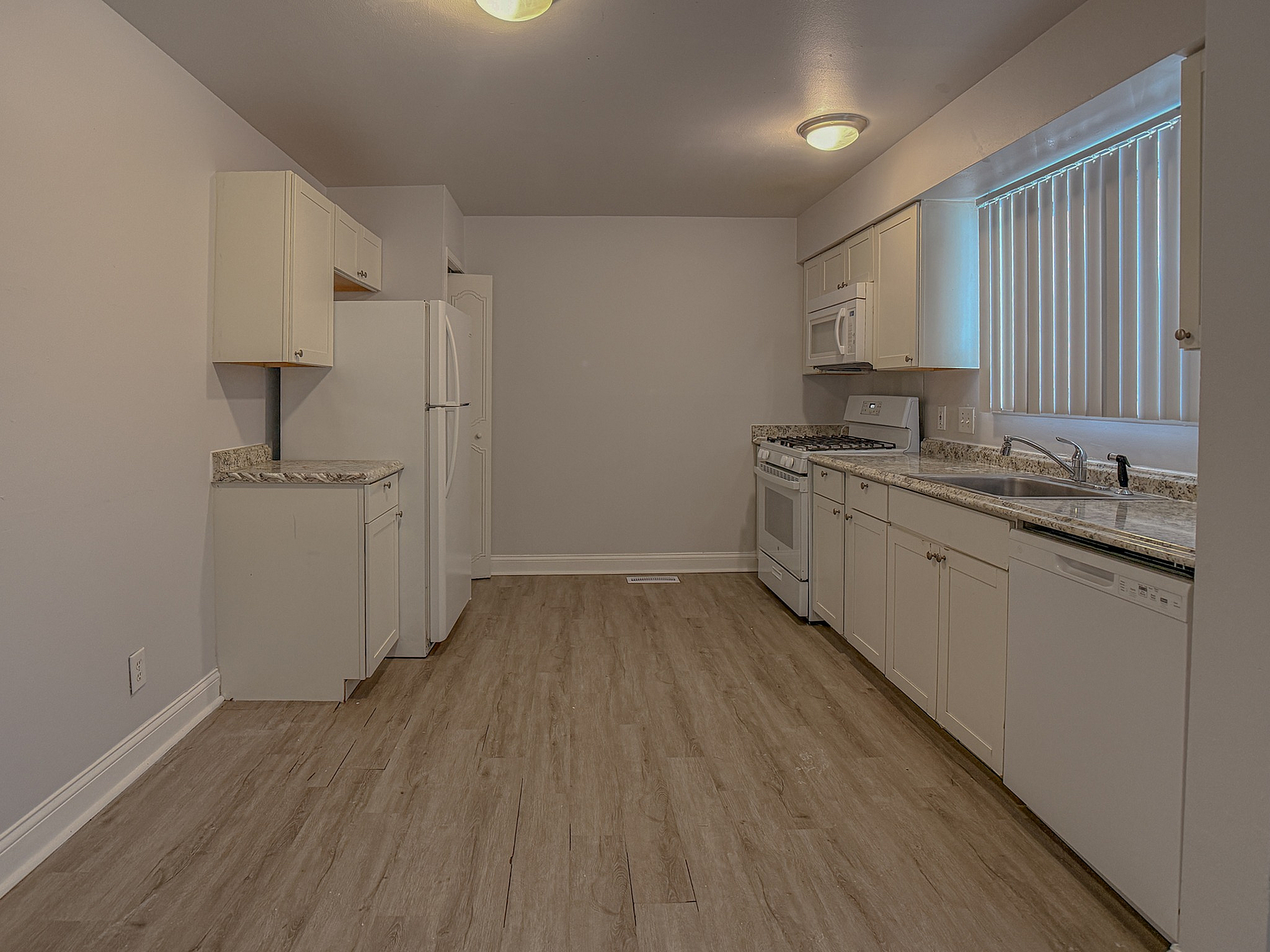 Modern kitchen with sleek cabinets, granite countertops, and elegant flooring offering ample space for culinary adventures.