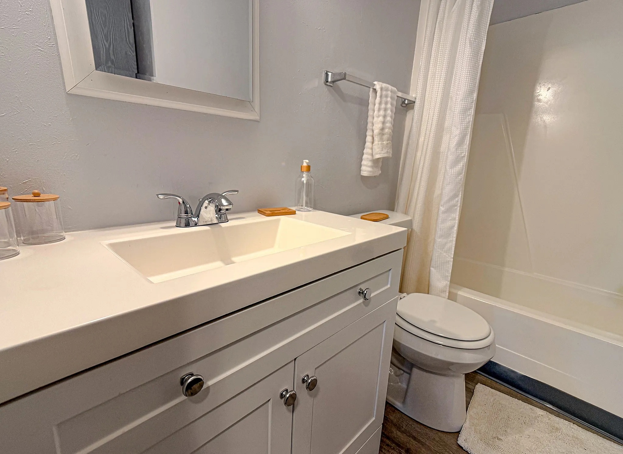 Bright and modern bathroom with sleek white cabinetry and a polished countertop, offering a serene retreat.