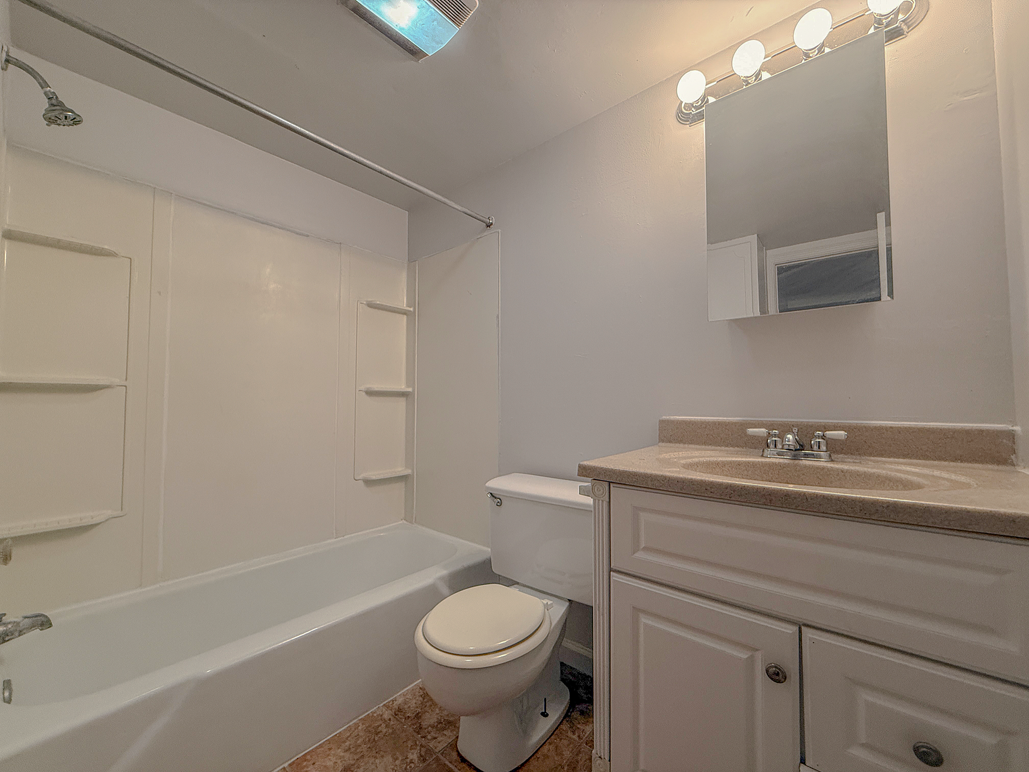 Bright and inviting bathroom with modern fixtures, sleek mirror, and a relaxing bathtub setup.