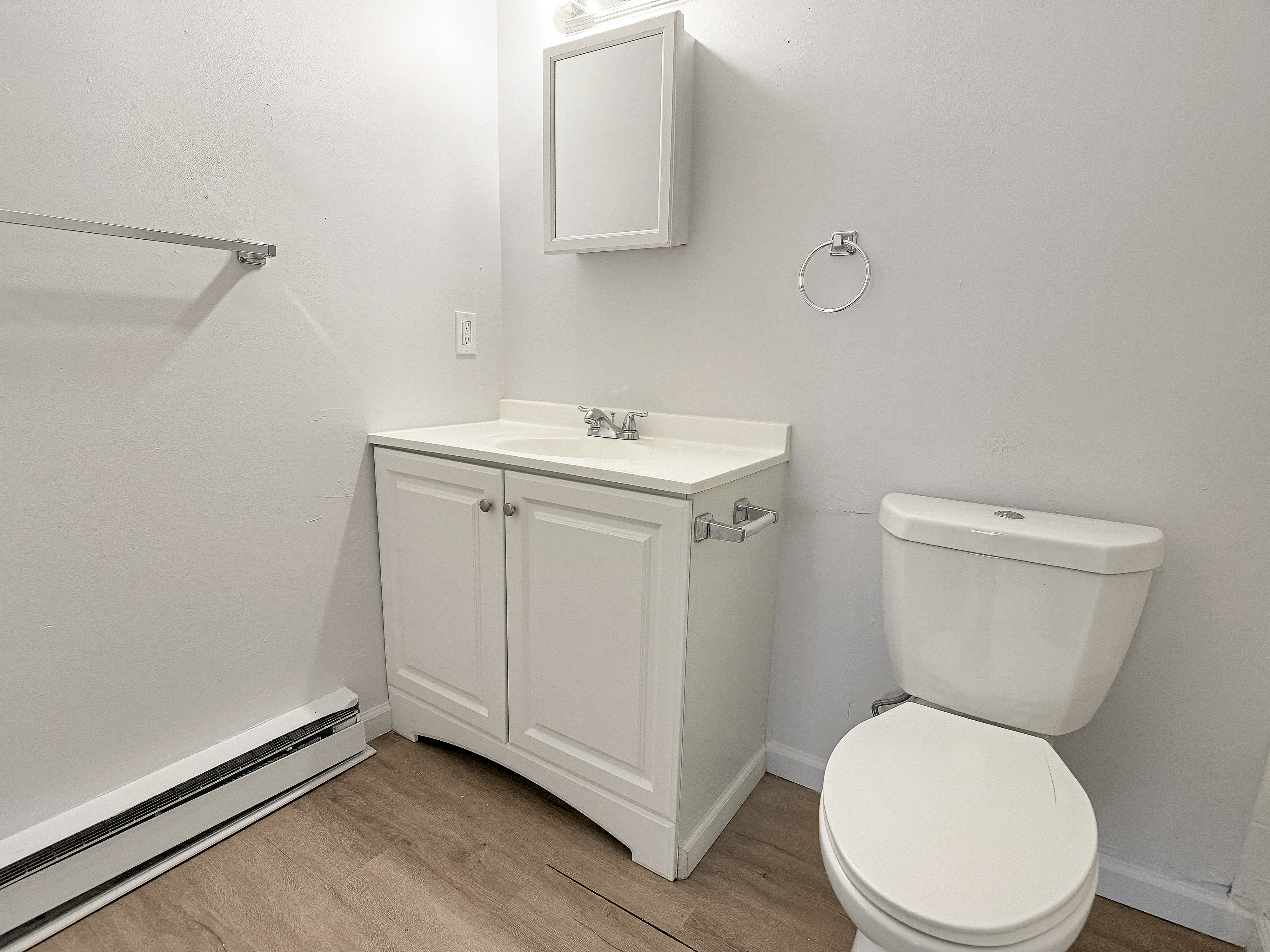 Bright and modern bathroom with sleek white cabinetry and efficient fixtures.