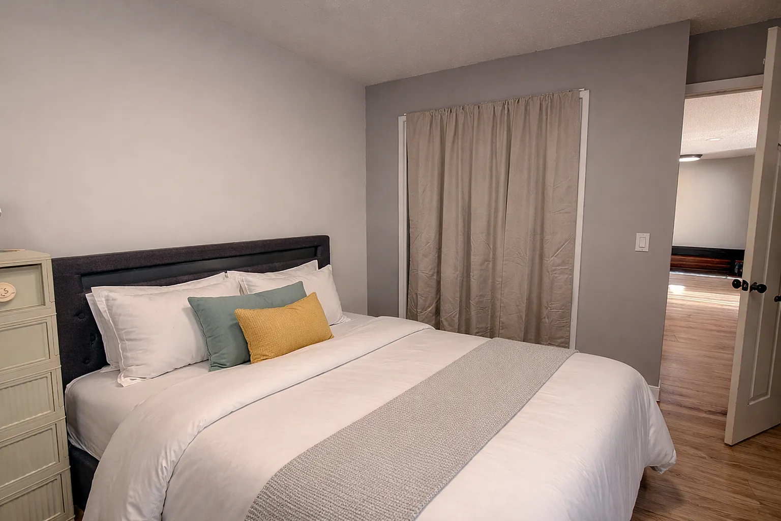 Cozy bedroom with plush bedding, elegant decor, and warm neutral tones, offering a serene retreat.