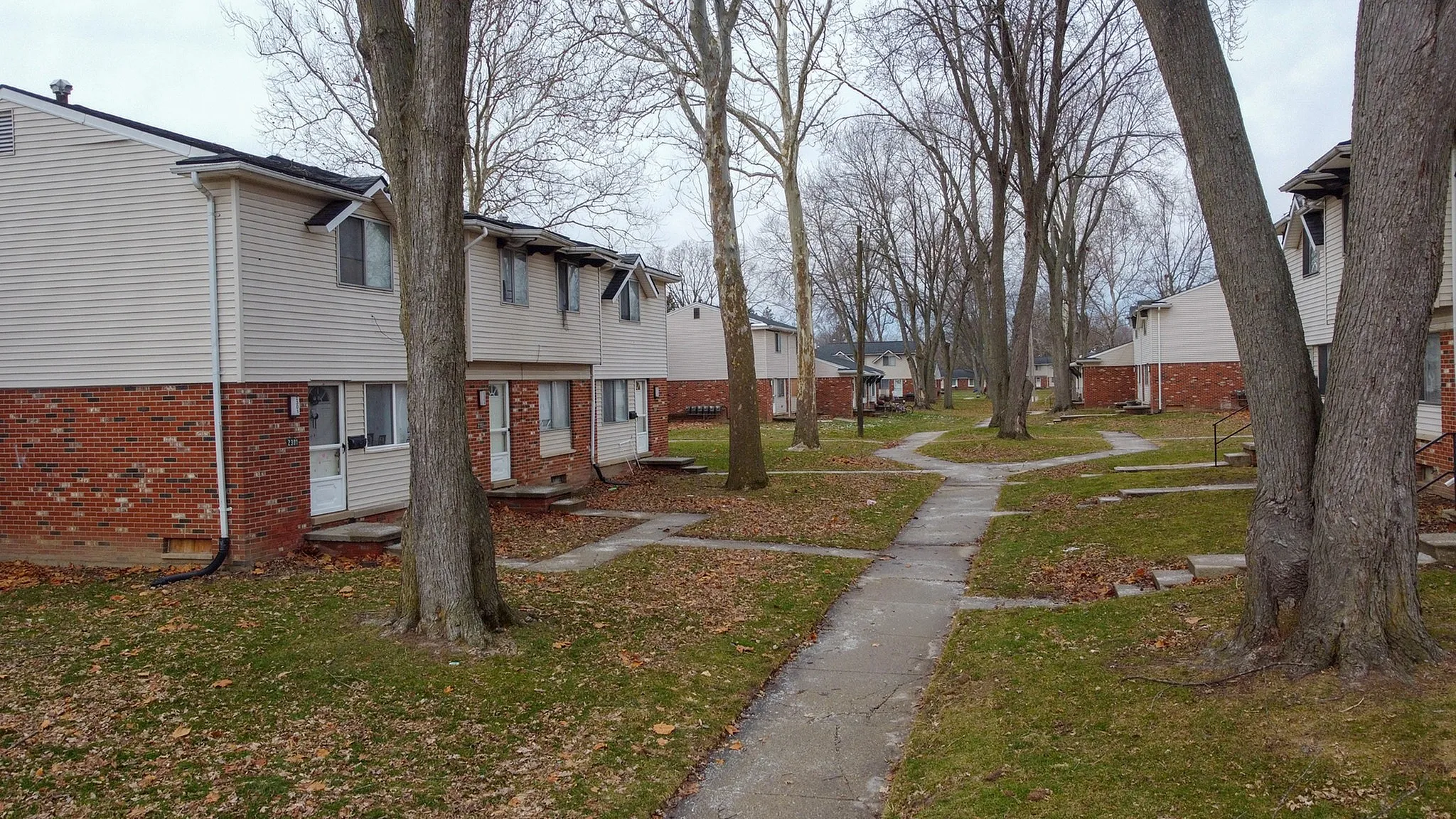 Charming townhouse community surrounded by mature trees and inviting pathways, creating a serene living environment.