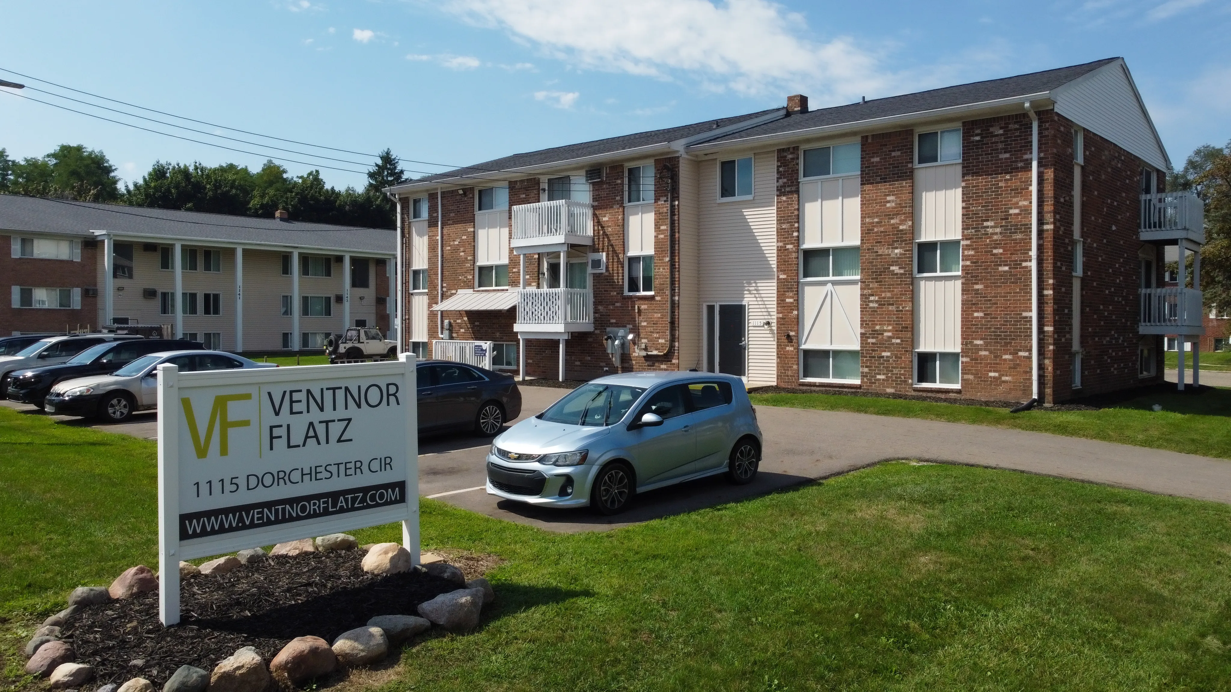 Charming residential community at Ventnor Flatz with lush greenery, ample parking, and inviting balconies.