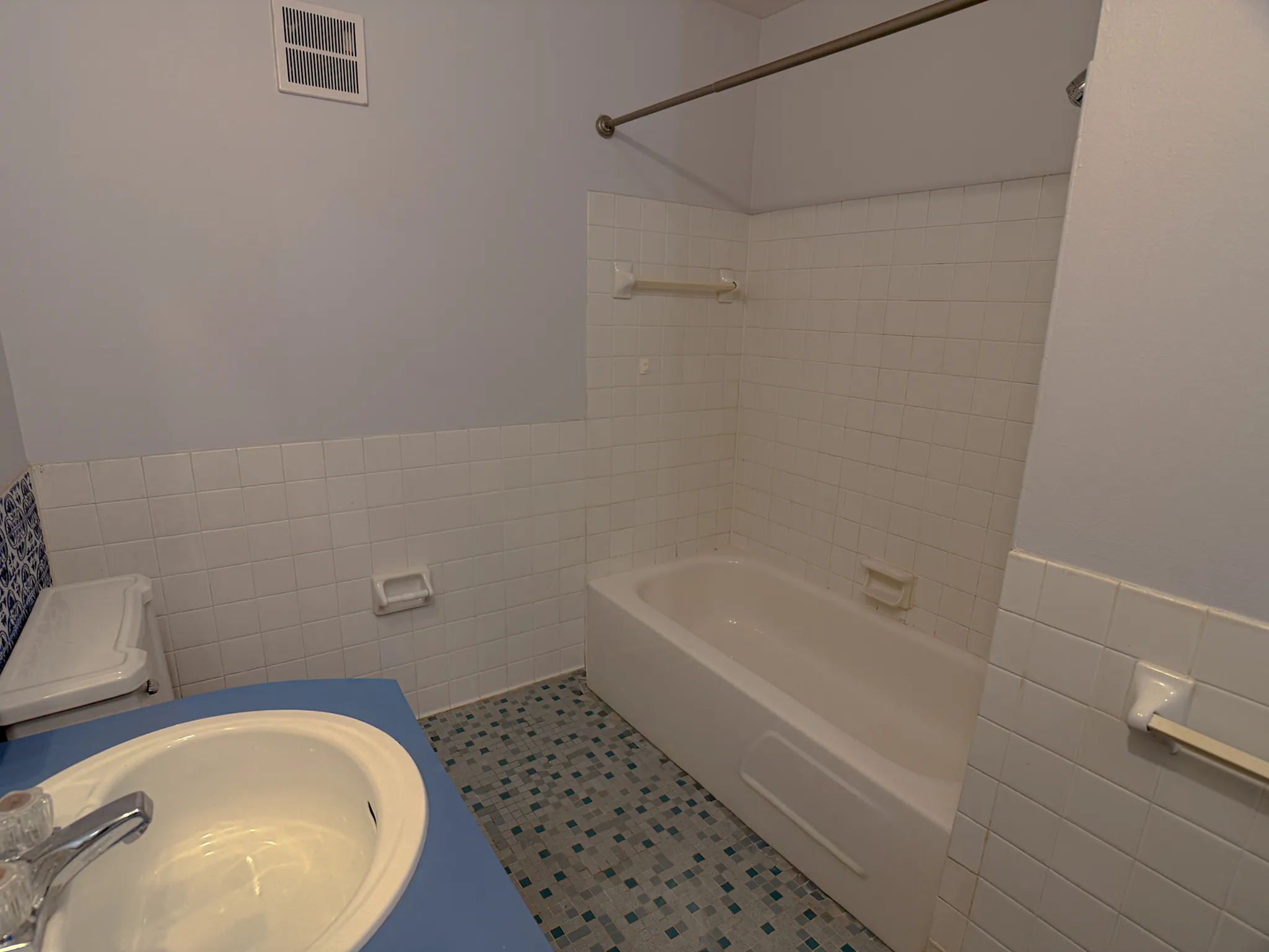 Charming bathroom with classic white tiles, a spacious bathtub, and sleek sink, perfect for relaxation and comfort.