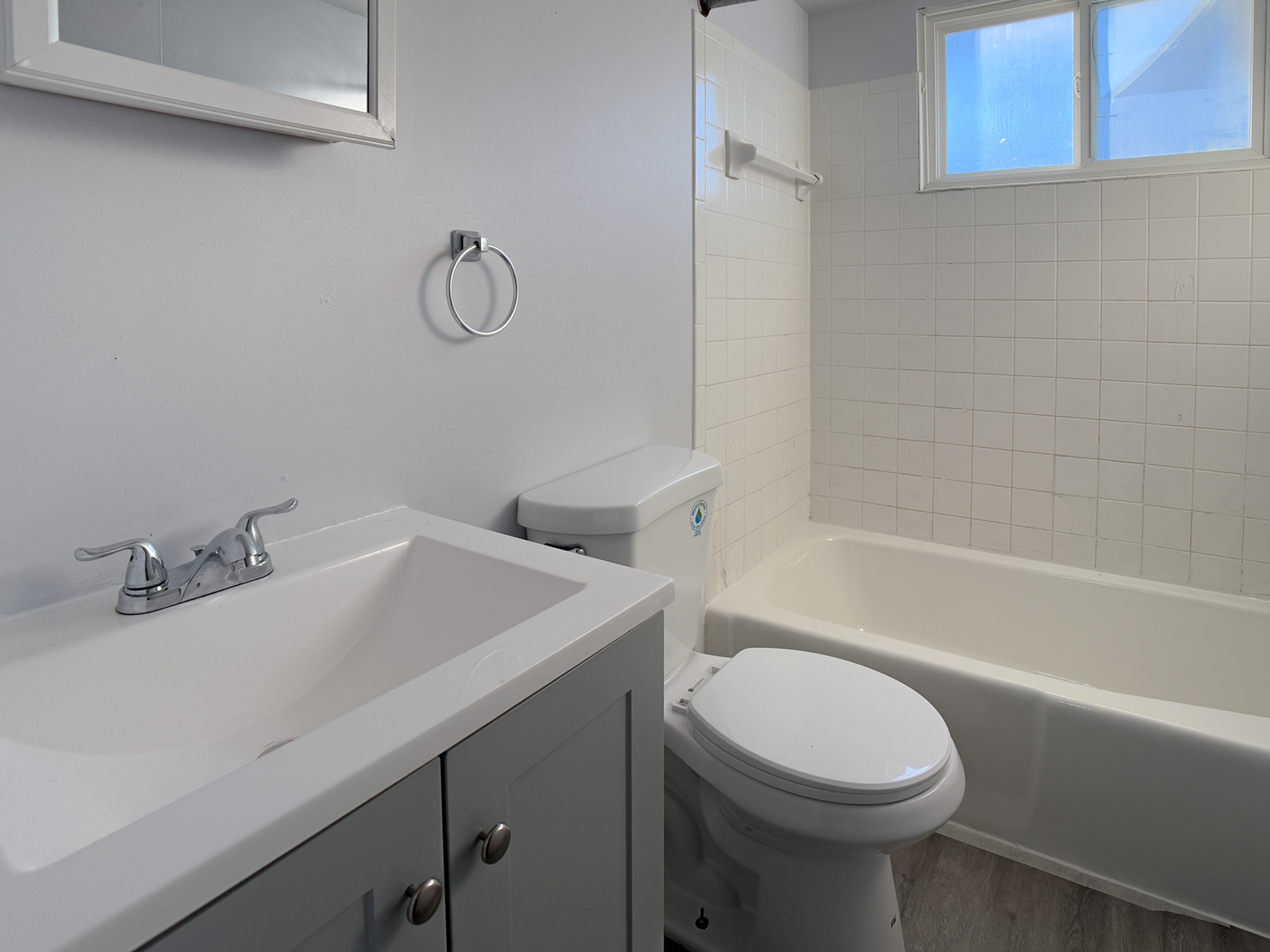 Sleek, modern bathroom with white fixtures, a stylish vanity, and bright natural light.