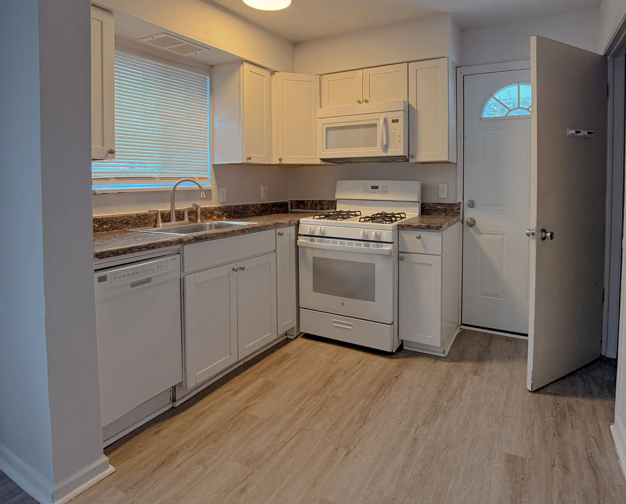 Charming kitchen featuring modern white cabinetry, sleek countertops, and stainless steel appliances.