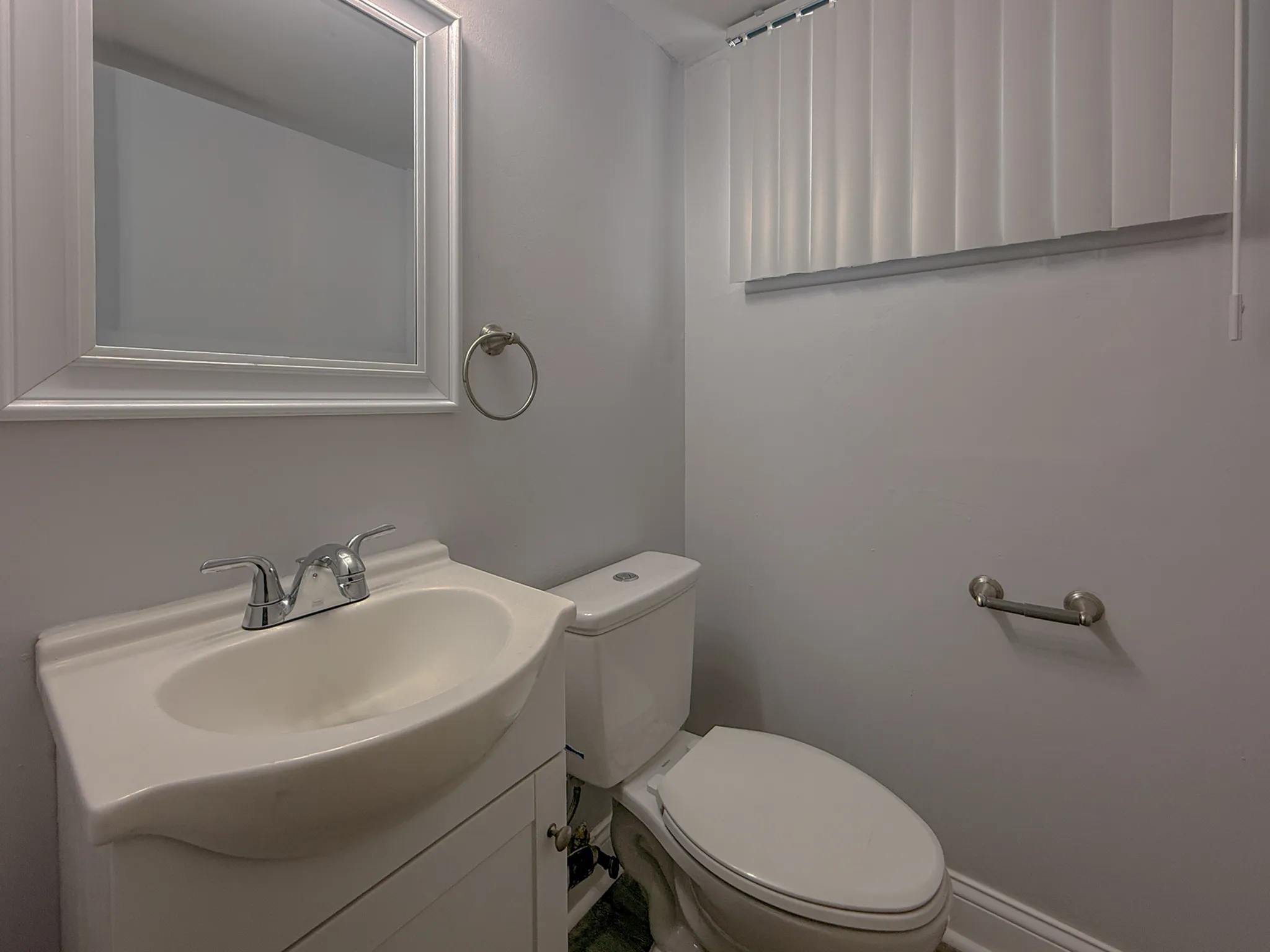 Bright and modern bathroom with sleek fixtures, featuring a stylish sink and elegant mirror.