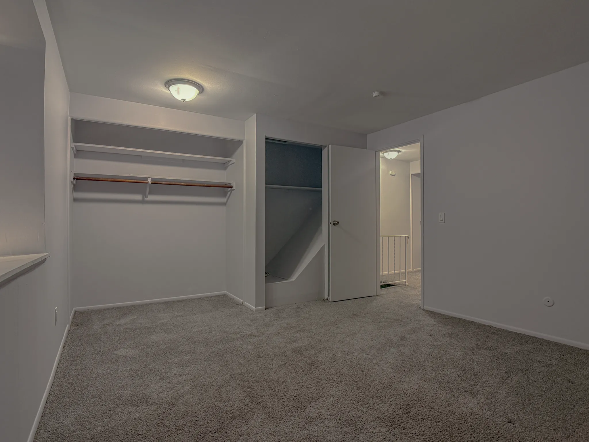 Spacious walk-in closet with built-in shelving and open space, perfect for organizing.