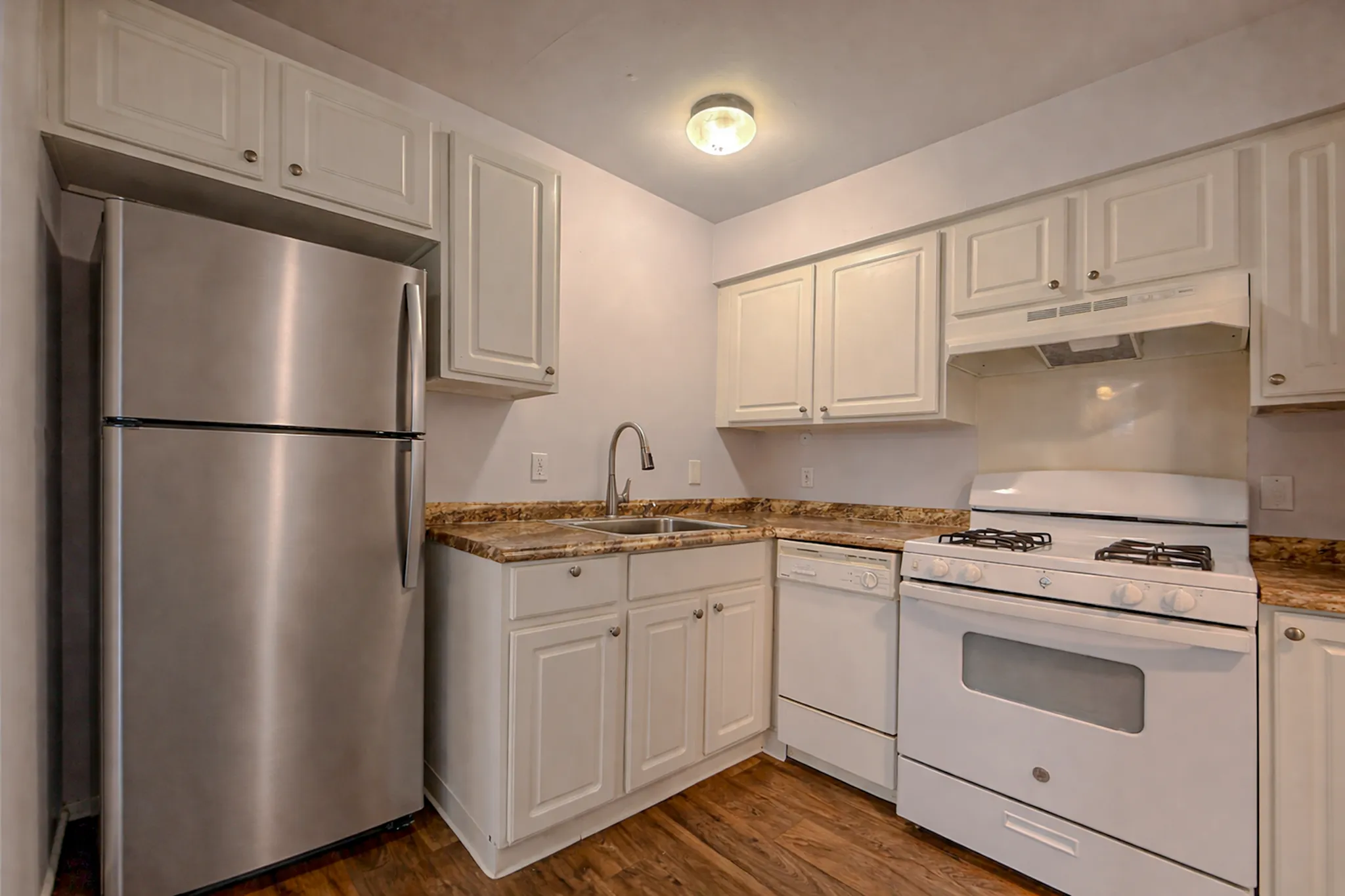 Charming kitchen with modern stainless steel fridge, elegant cabinetry, and sleek countertops.