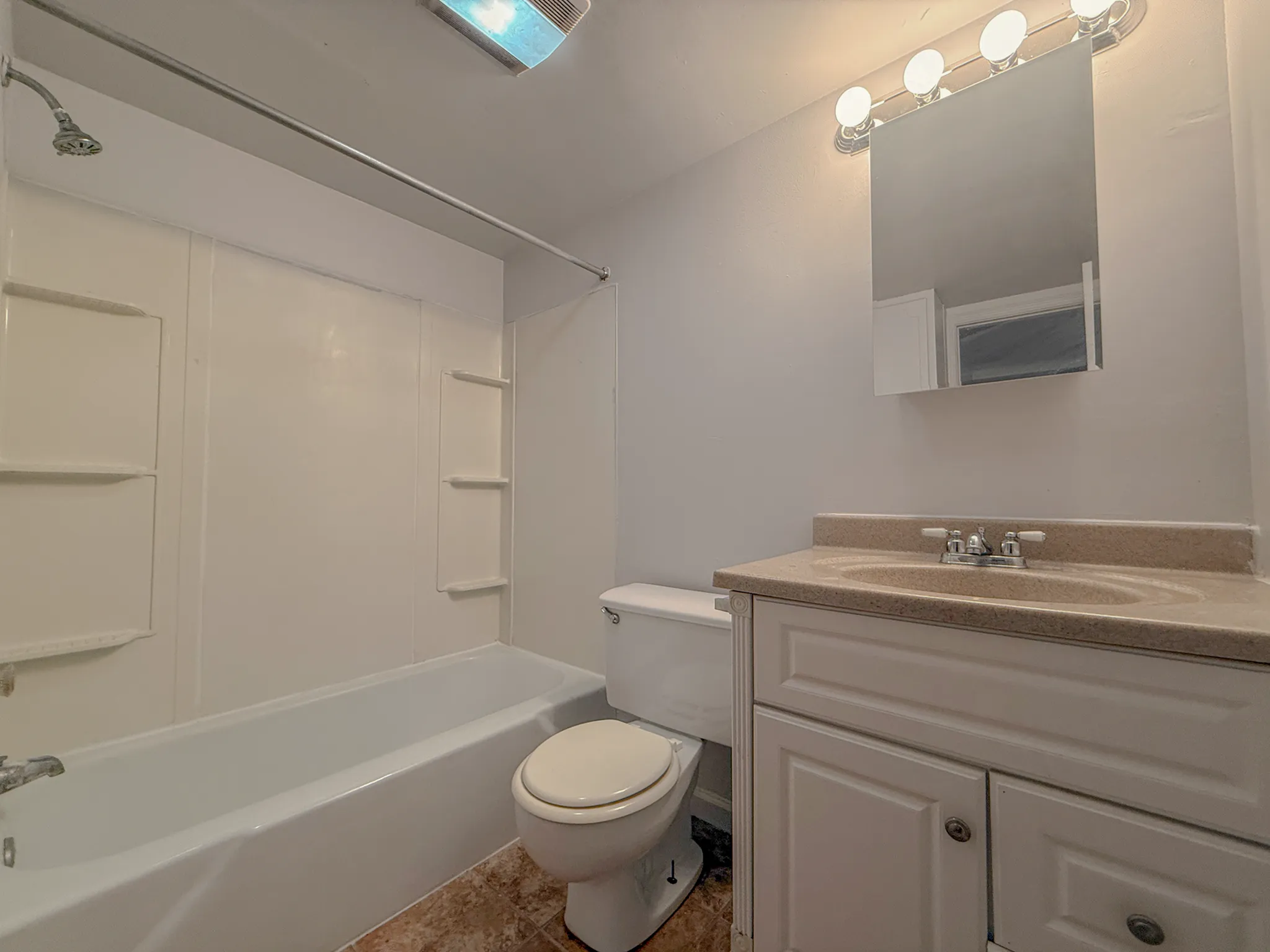Elegant bathroom with modern vanity, bright lighting, and classic bathtub design.