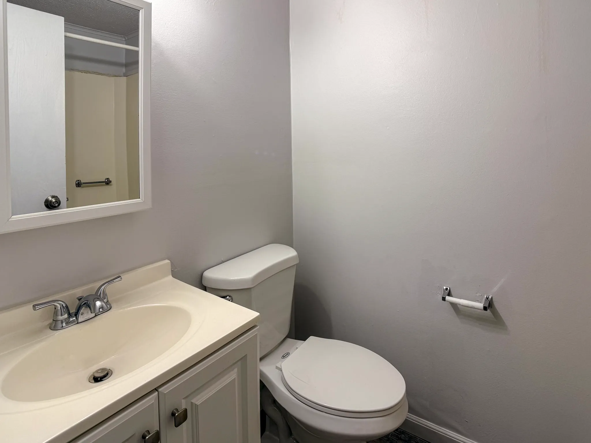 Modern bathroom with a sleek white vanity and a polished chrome faucet, featuring a clean and inviting atmosphere.