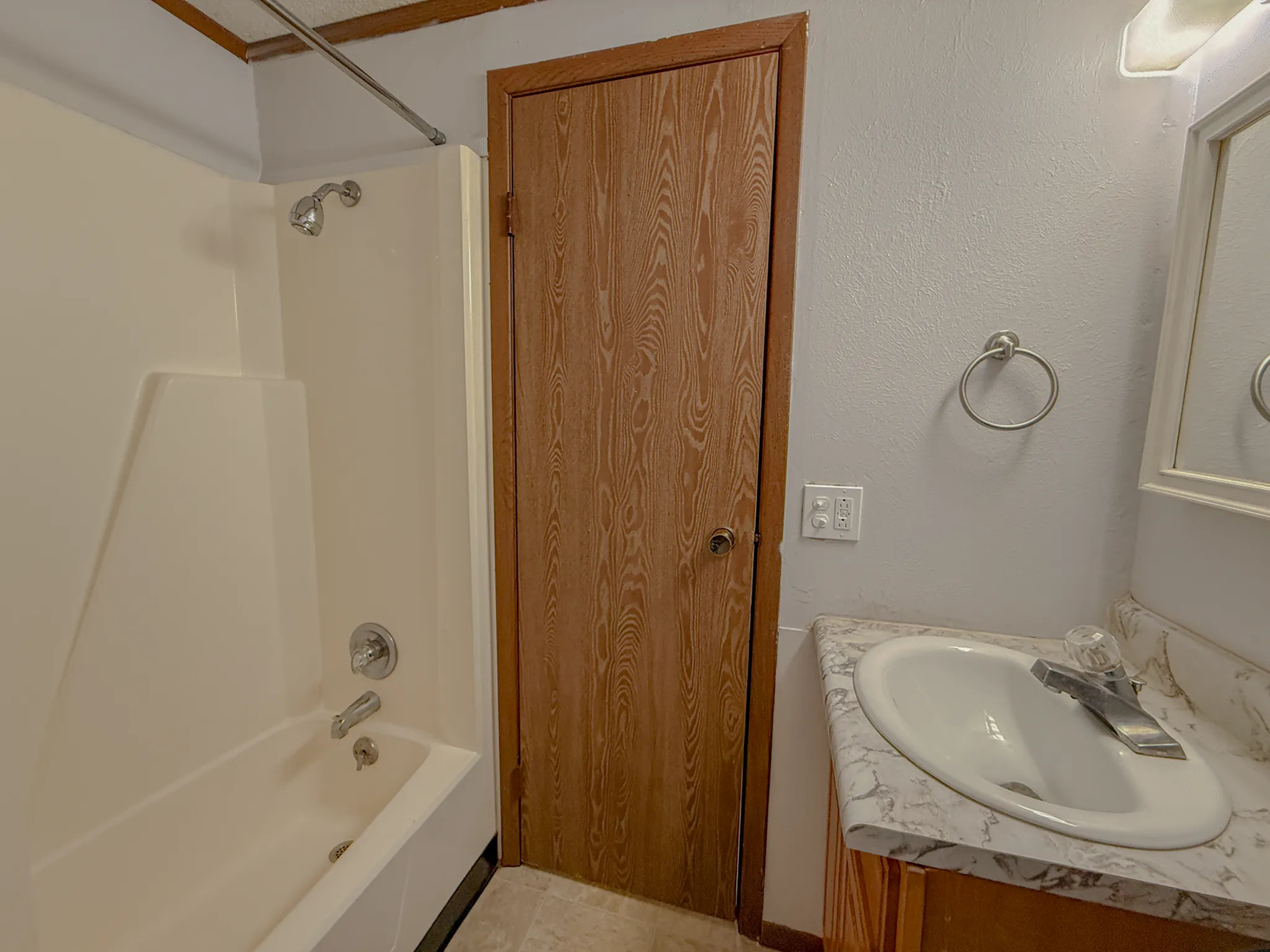 Inviting bathroom with a modern bathtub and elegant marble countertop, highlighting bright and cozy interiors.
