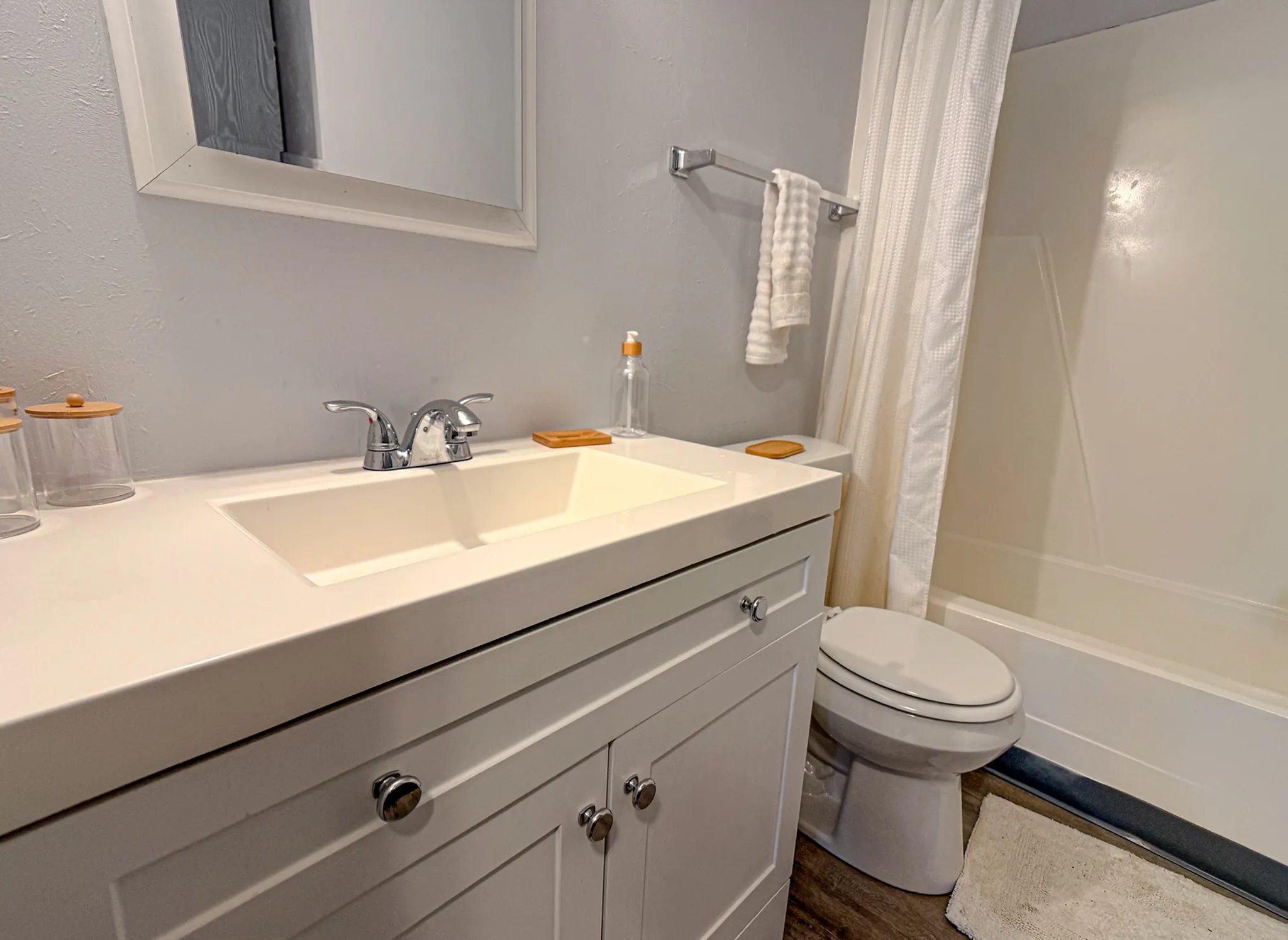 Elegant bathroom with modern vanity, sleek fixtures, and a spacious bathtub for ultimate comfort.