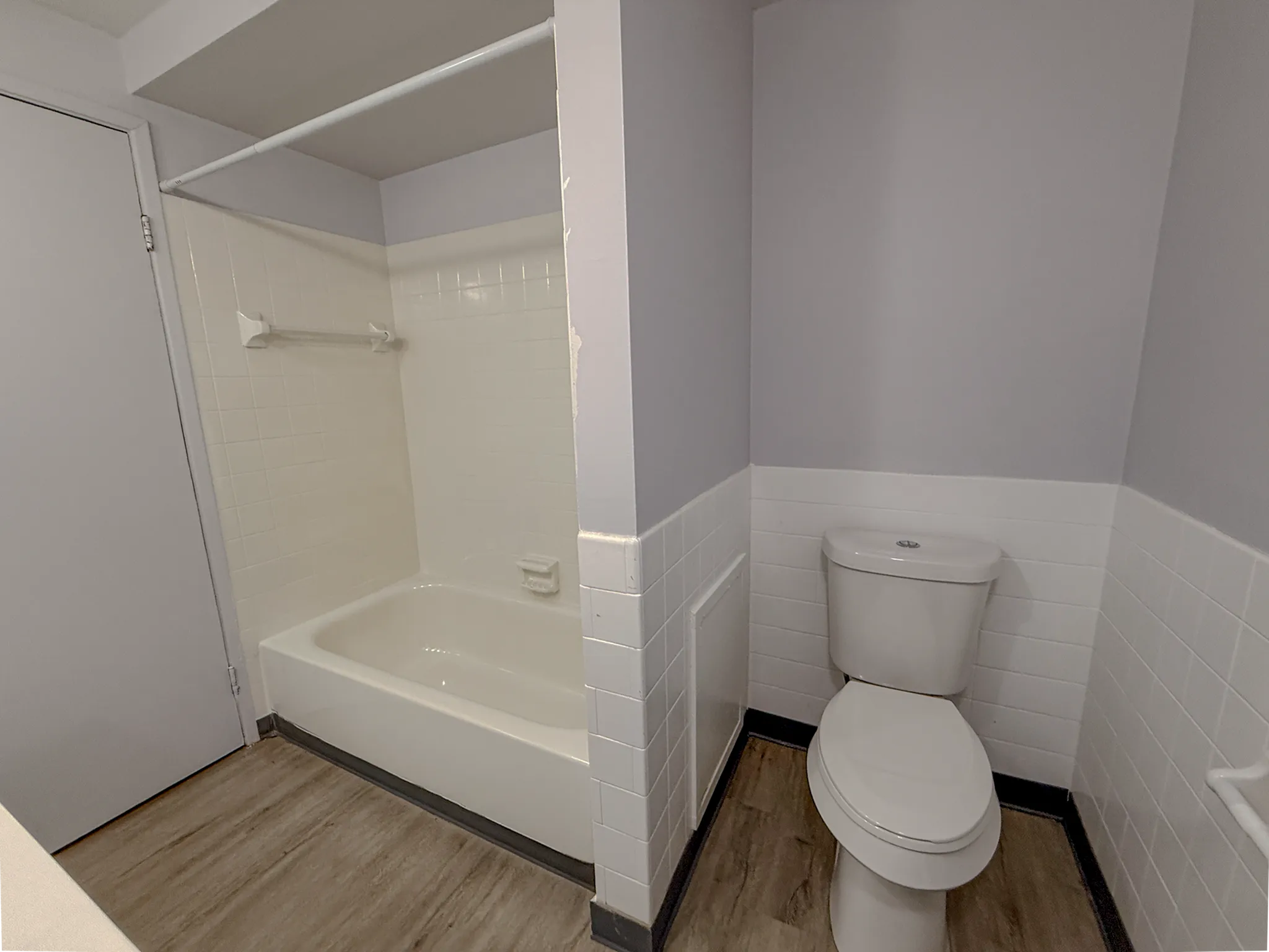 Modern bathroom in a chic apartment featuring a sleek bathtub, stylish tiling, and elegant flooring.
