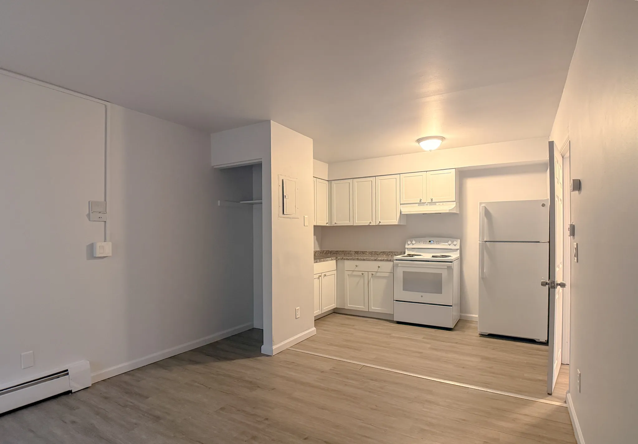 Modern apartment kitchen with sleek white cabinetry, spacious counter space, and integrated appliances.