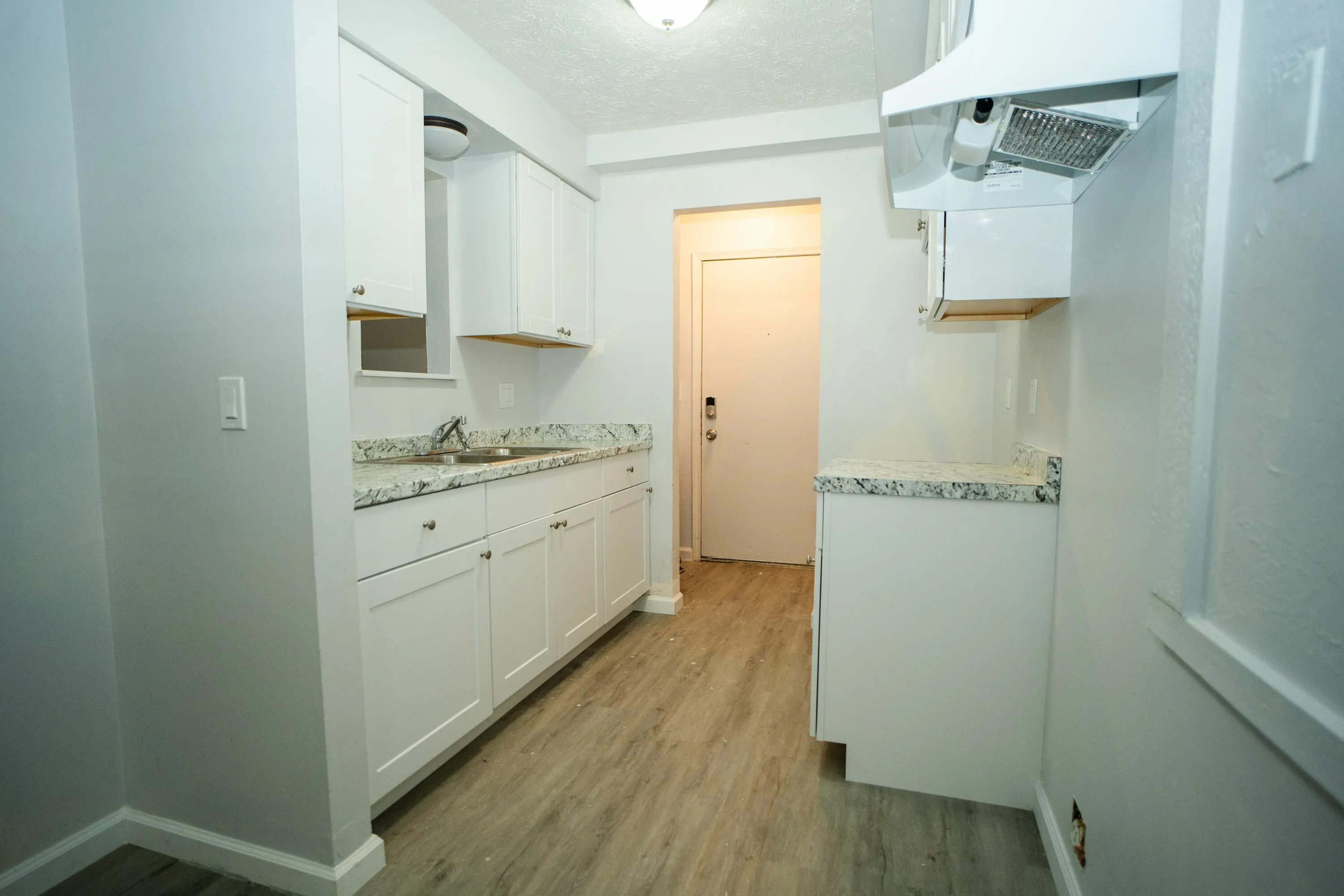 Sleek modern kitchen with elegant countertops, stylish cabinets, and pristine flooring, creating a welcoming atmosphere.