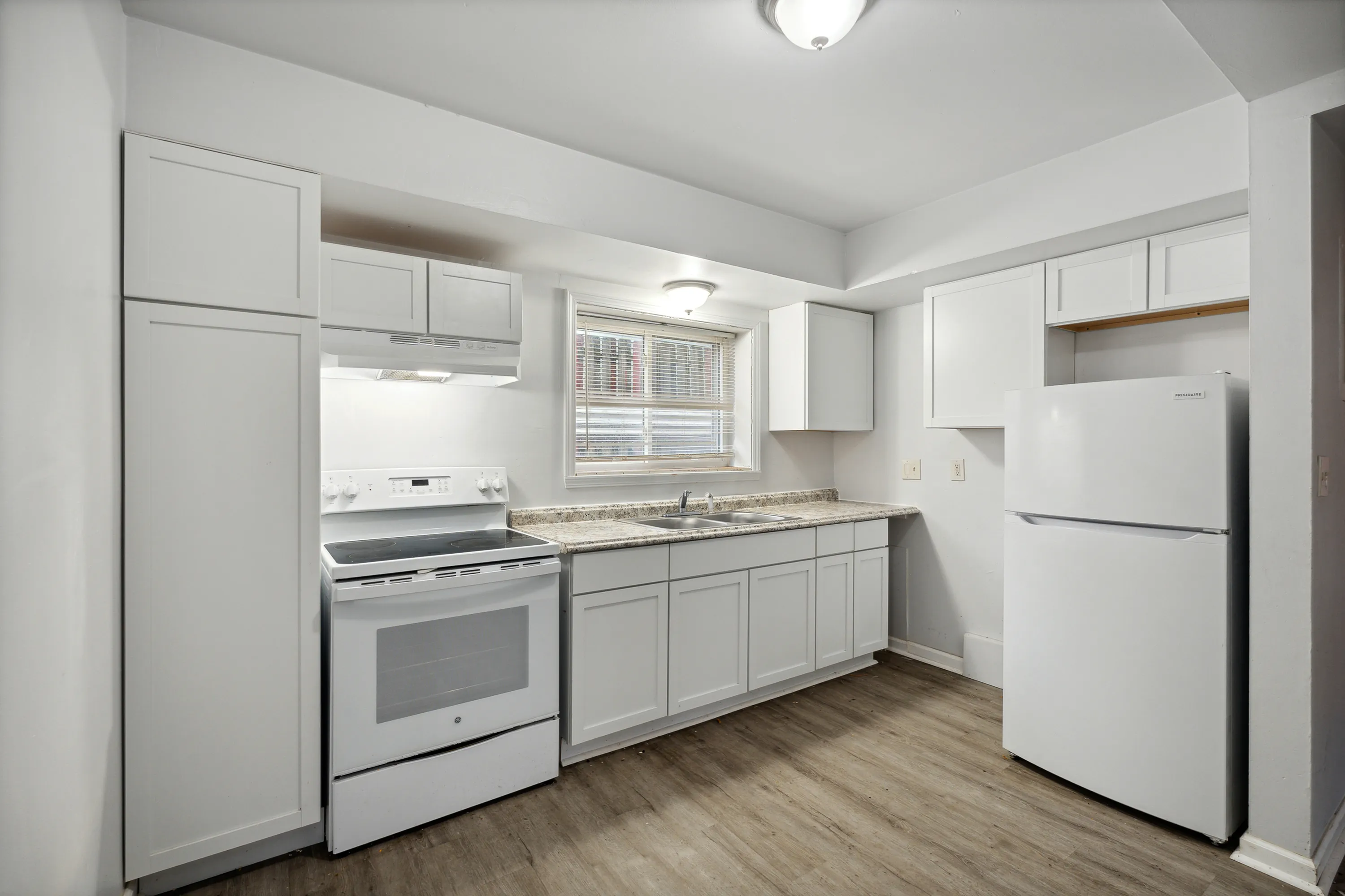 Modern kitchen with sleek white cabinets, spacious countertops, and stainless steel appliances, offering a bright and inviting cooking space.
