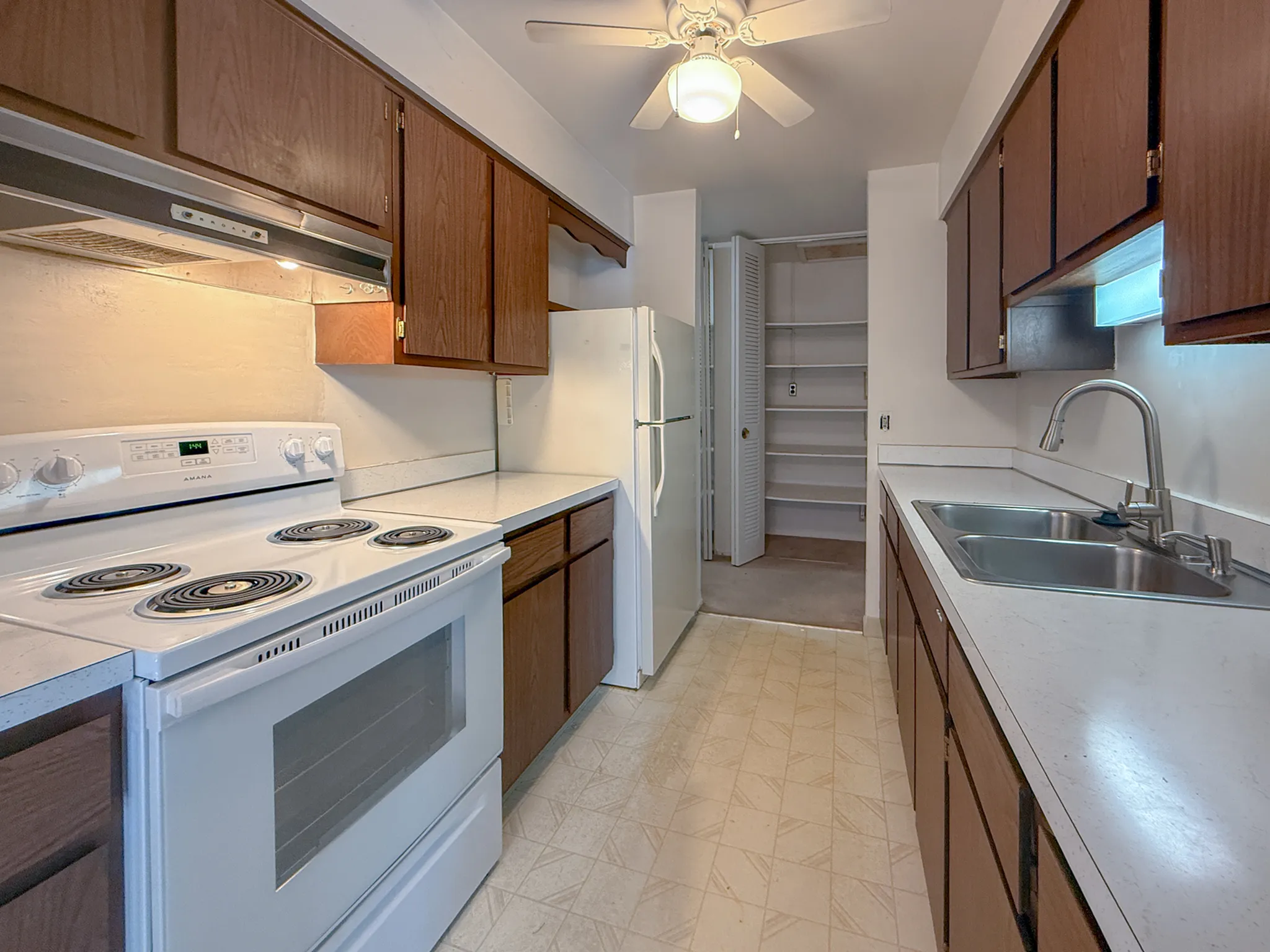 Inviting kitchen with warm wooden cabinetry, modern appliances, and ample storage space.