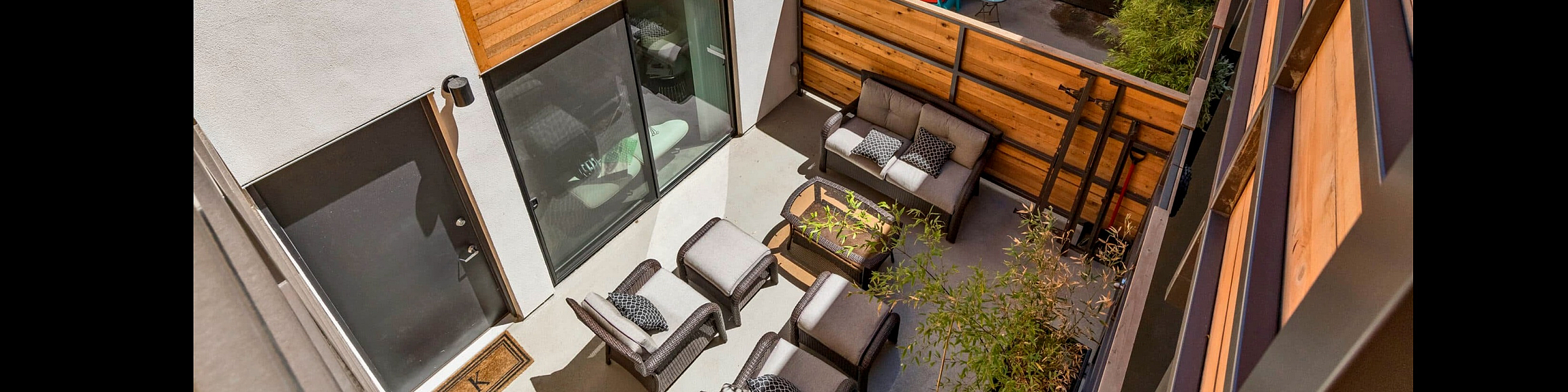 Chic outdoor courtyard with stylish seating, natural wood accents, and lush greenery, offering a serene escape in urban living.