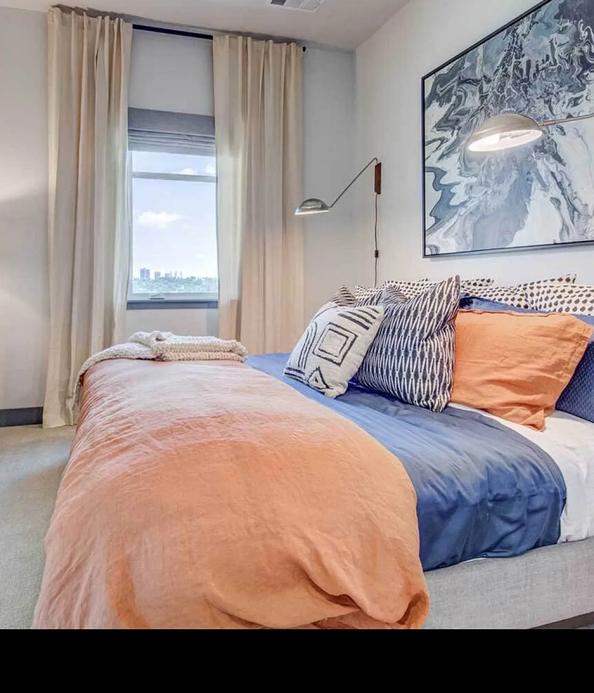 Elegant bedroom with a stunning city view, featuring modern decor, cozy bedding, and soft, natural lighting.