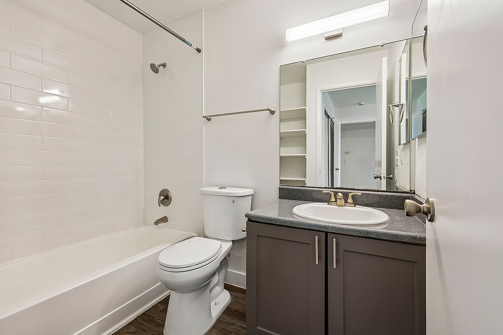 Modern bathroom featuring sleek white tiling, elegant vanity, and a spacious bathtub for ultimate relaxation.