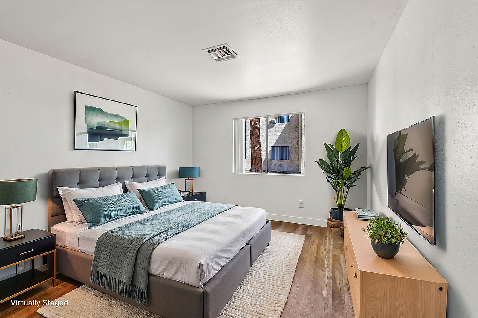Modern, virtually staged bedroom featuring a cozy bed with teal accents, stylish artwork, and a smart TV, illuminated by natural light and complemented by vibrant indoor plants.