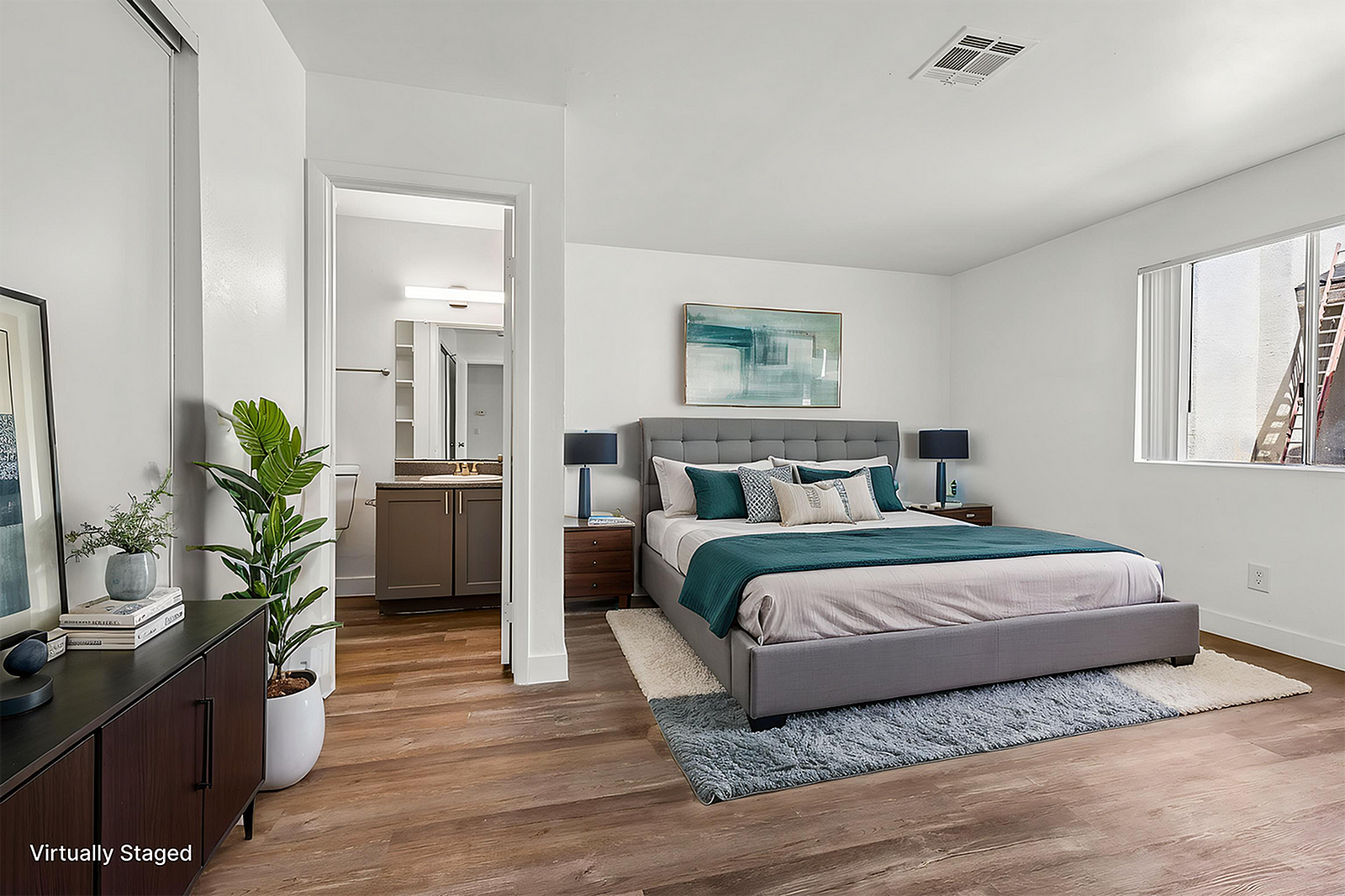 Elegant bedroom with contemporary decor, featuring a plush king bed, stylish artwork, and natural light from a large window. The room is complemented by sleek wooden flooring and calming neutral tones.