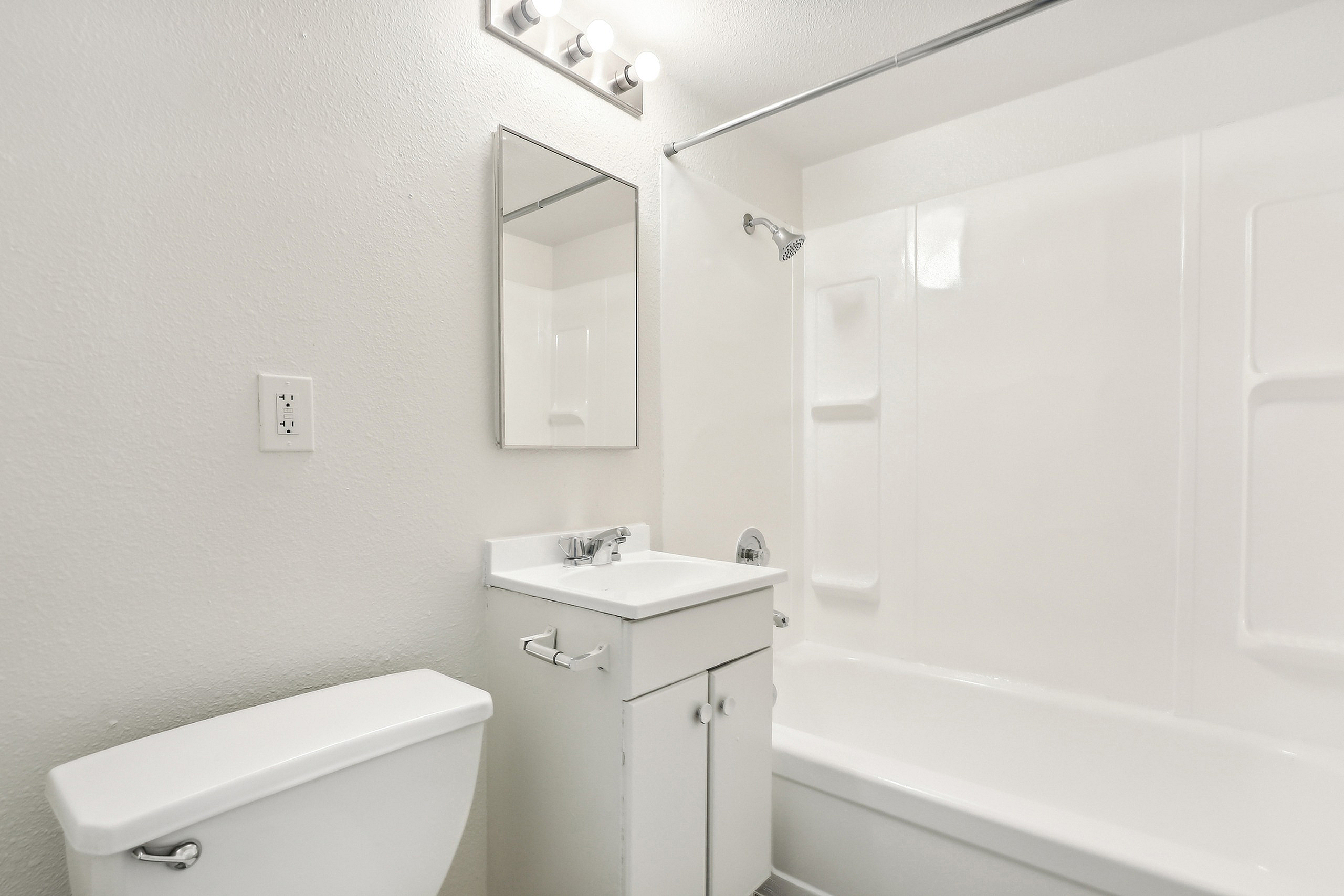 Bright, modern bathroom featuring sleek fixtures, a clean vanity, and a pristine bathtub.