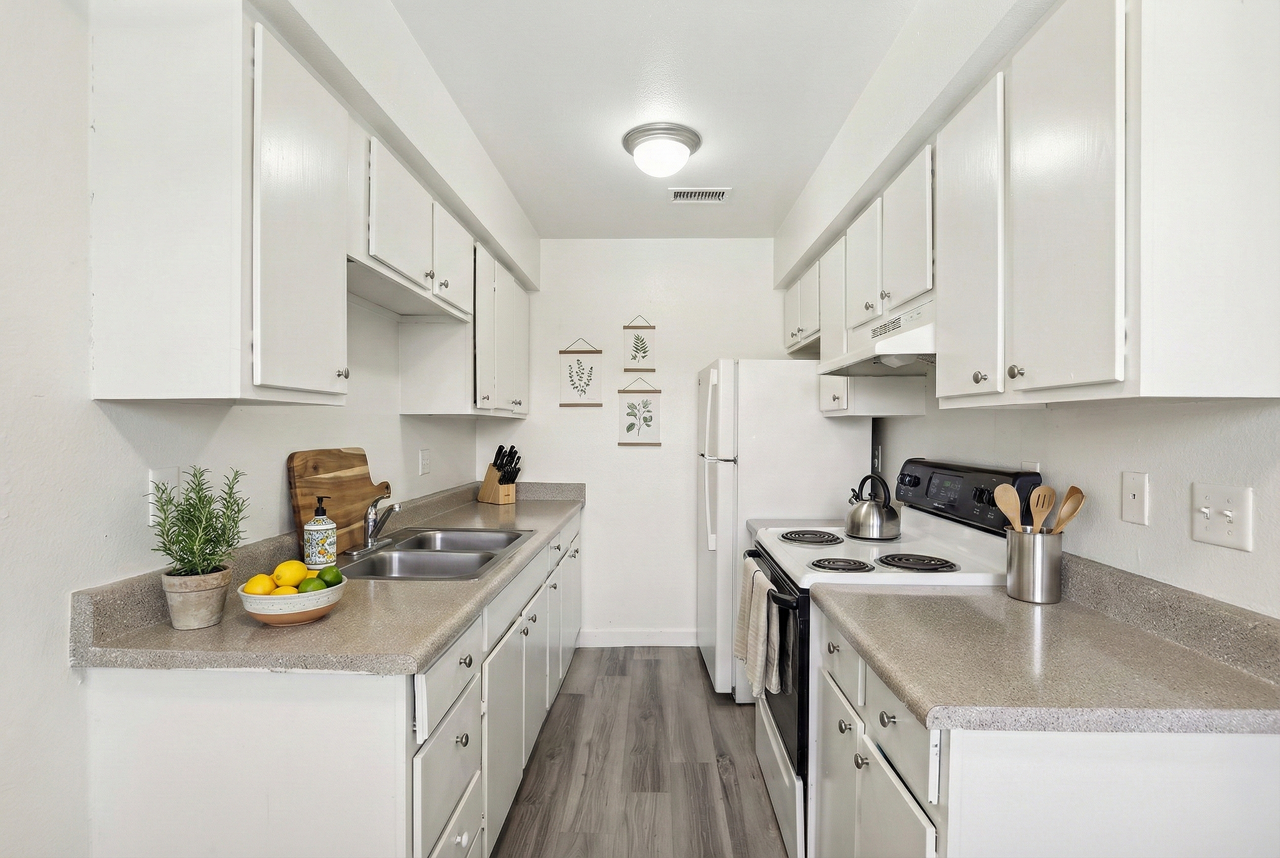 Bright and inviting kitchen with modern white cabinets, sleek countertops, and elegant appliances, perfect for culinary enthusiasts.