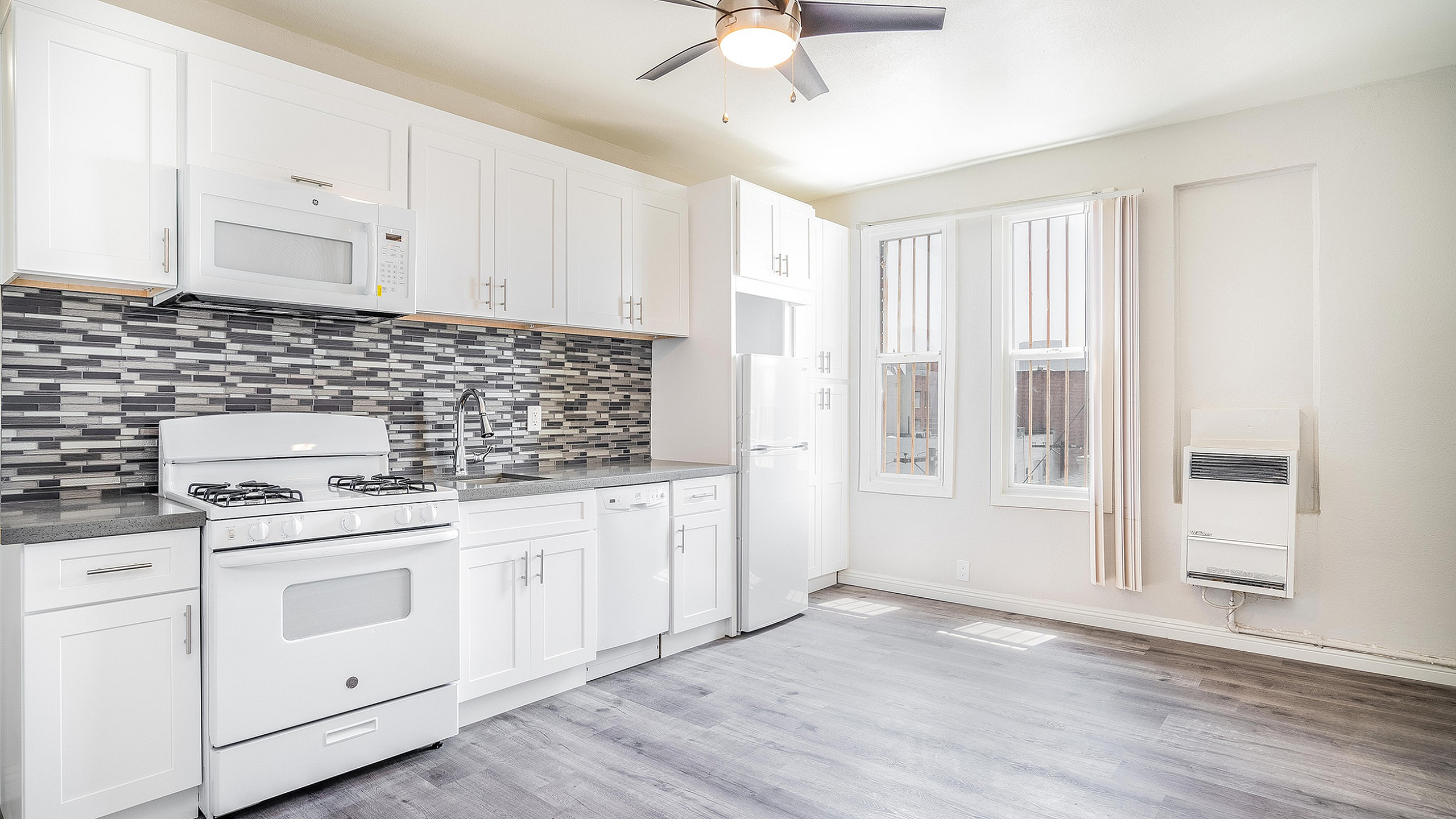 Bright, modern kitchen with stylish cabinetry, sleek countertops, and elegant tile backsplash, featuring ample natural light and contemporary appliances.