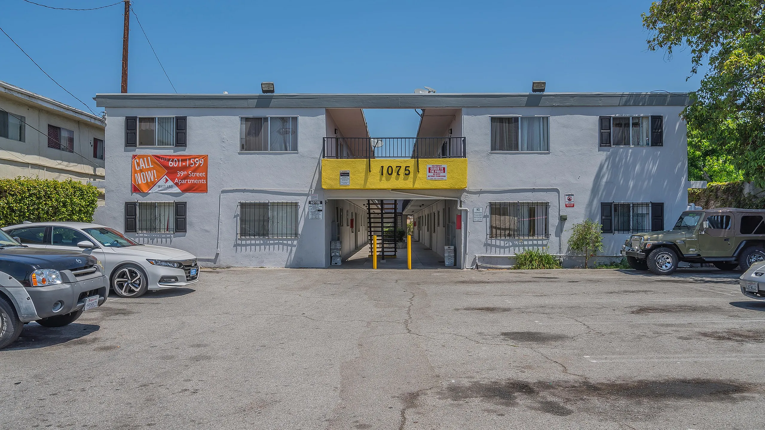 Inviting apartment complex with a modern facade, ample parking, and vibrant signage promoting vacancies at 1075 on 39th Street.