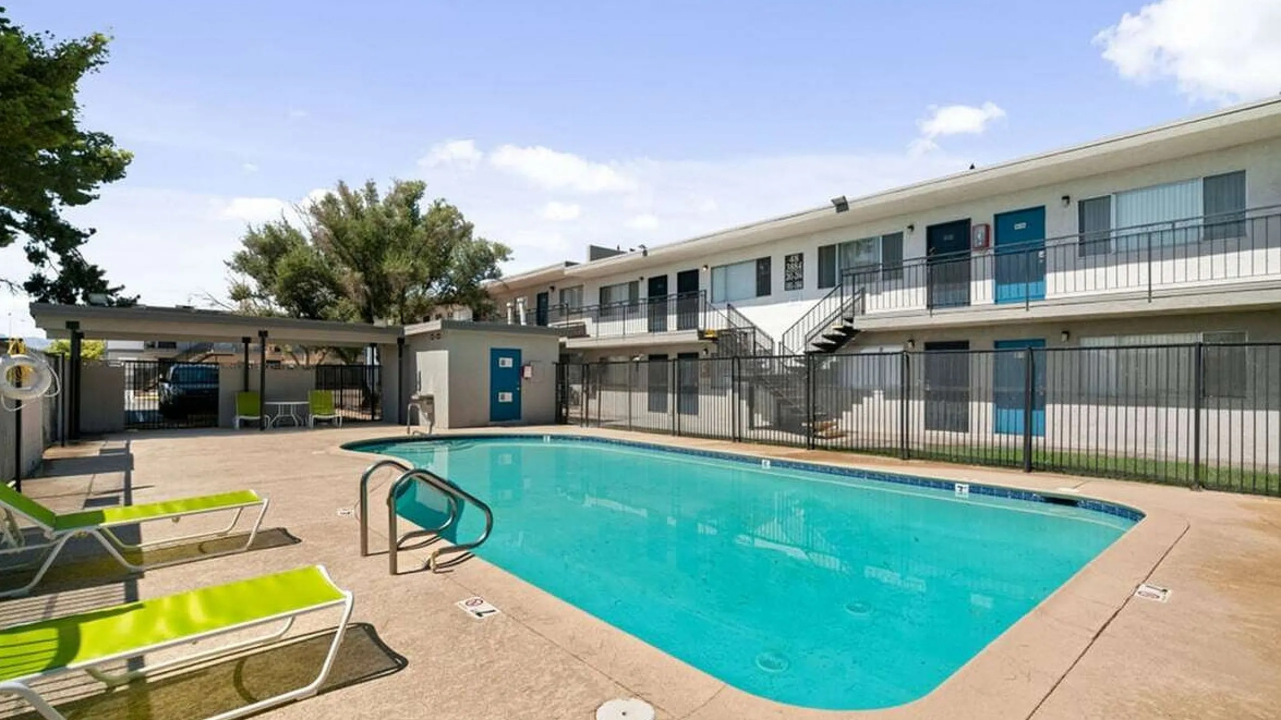 Inviting apartment complex with a sparkling outdoor pool, surrounded by relaxing lounge chairs, promising a perfect retreat for residents.
