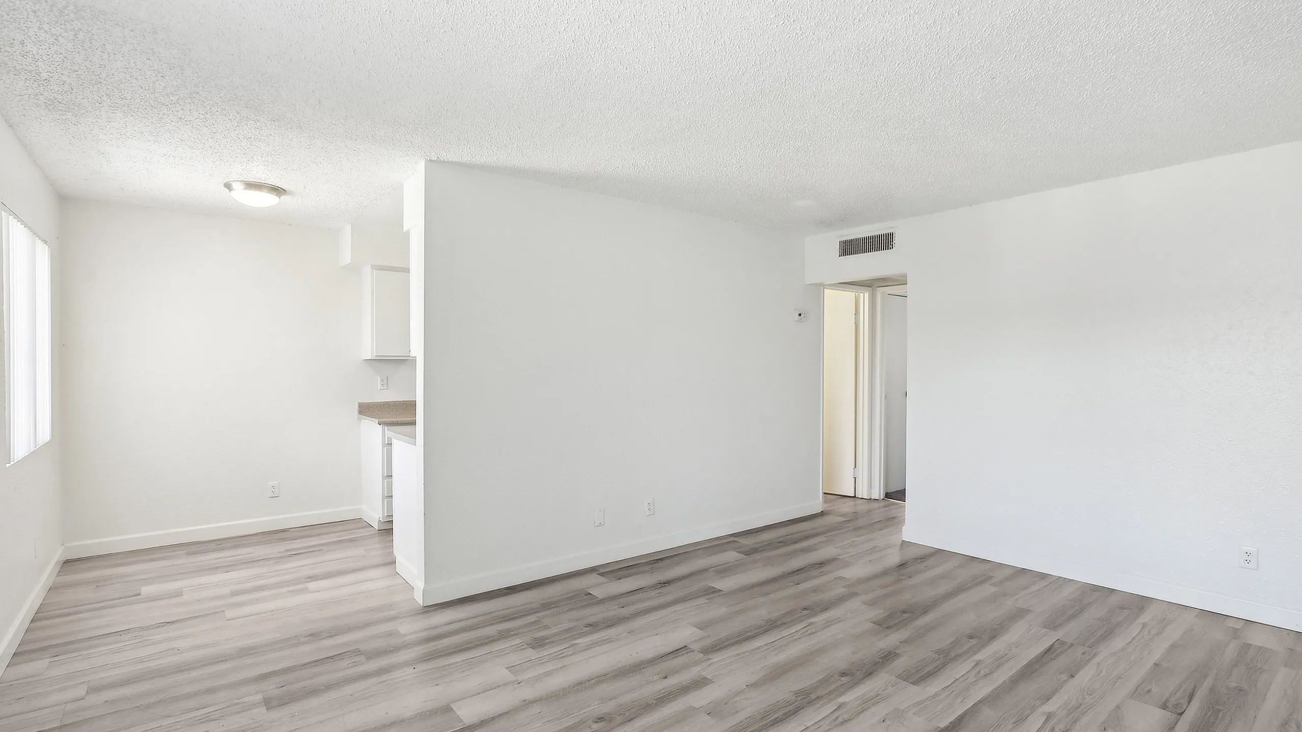 Bright and airy living space with sleek hardwood floors and modern kitchen design.