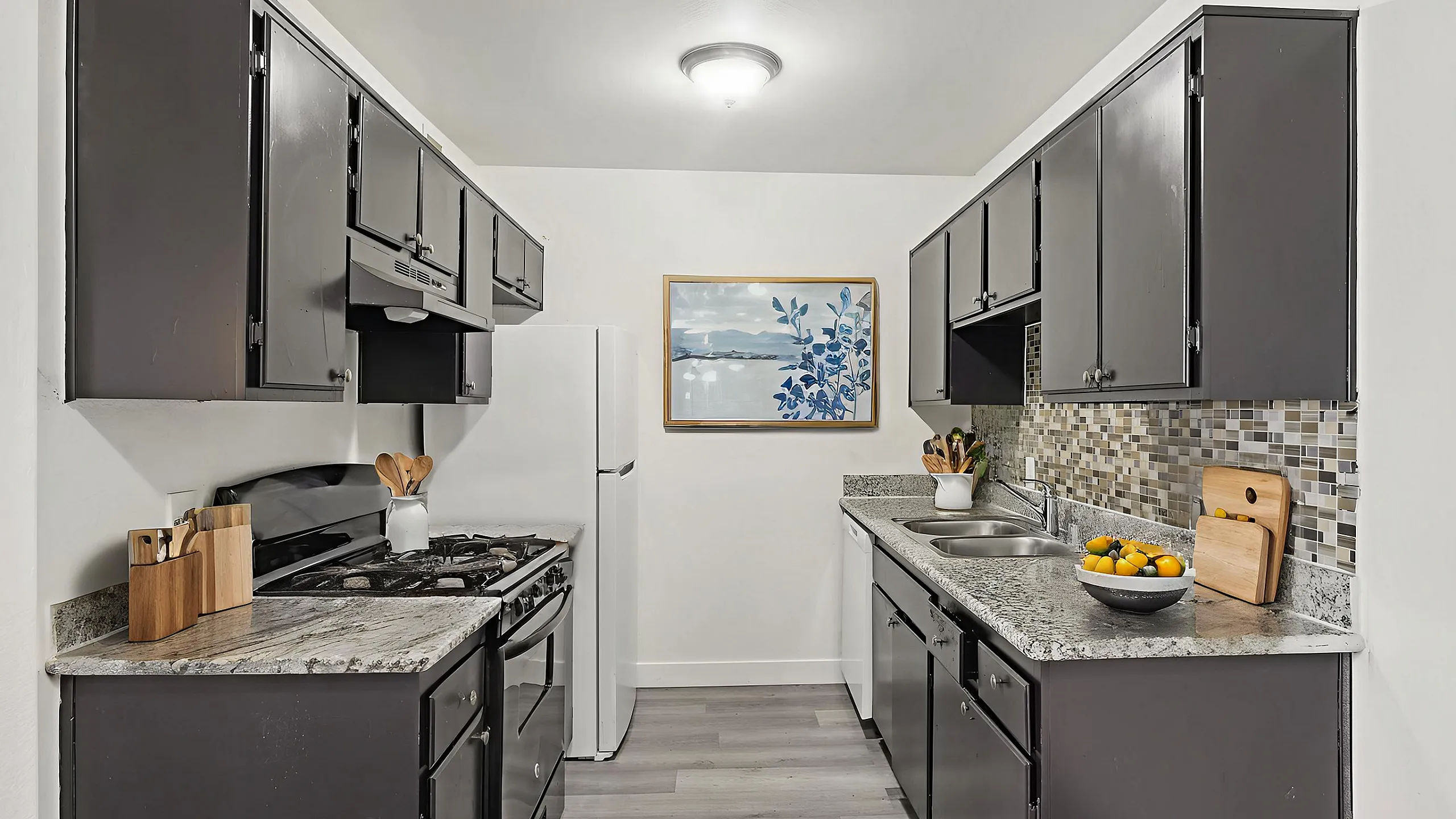 Contemporary kitchen with sleek black cabinets, granite countertops, and mosaic backsplash, perfect for modern living.