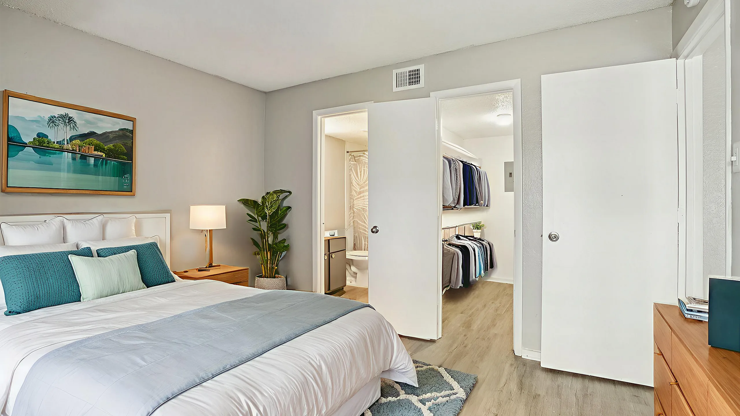 Chic modern bedroom with plush bedding, vibrant artwork, and spacious closet for stylish living.