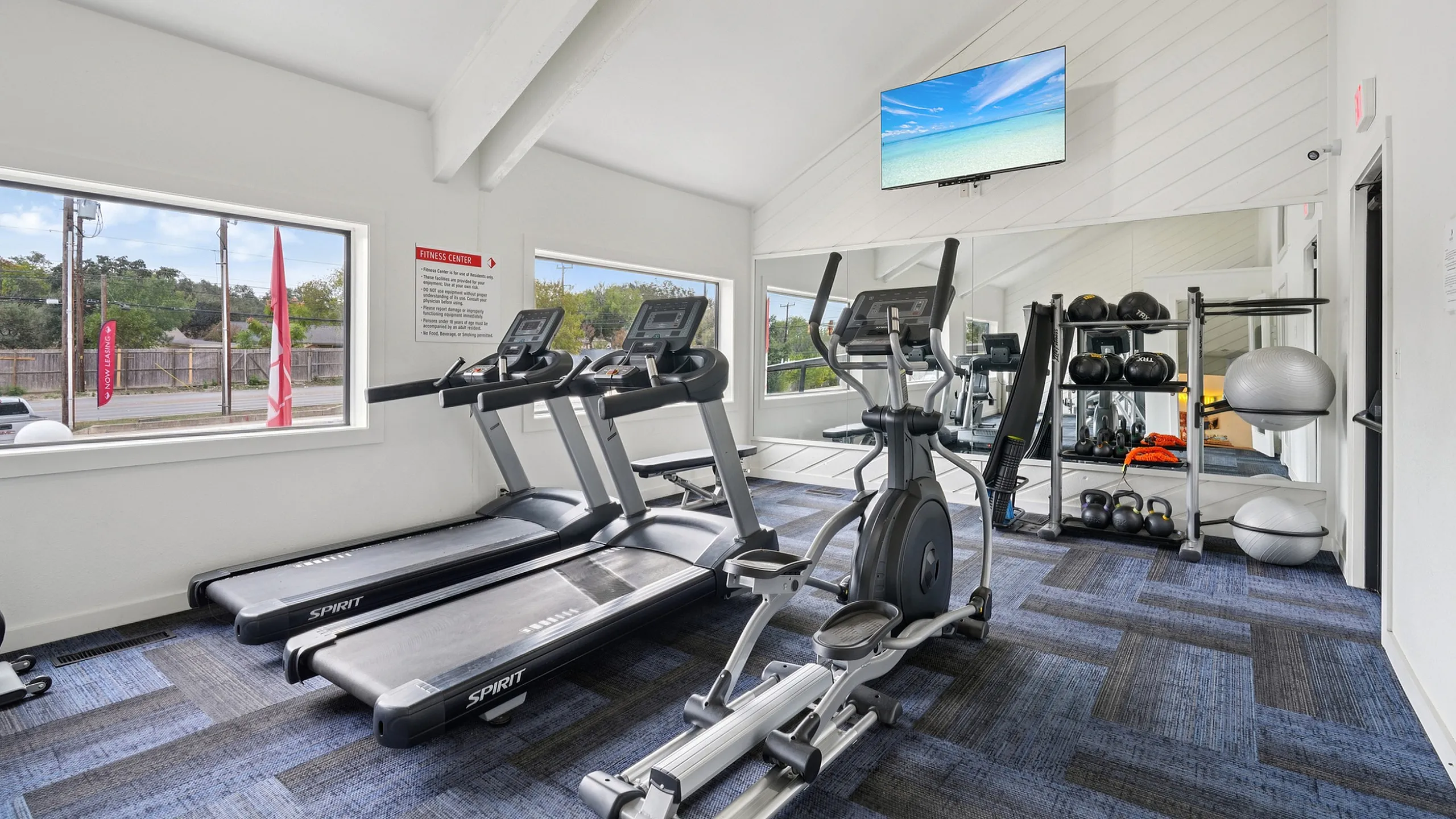 Elegant fitness center with bright windows, modern treadmills, and well-equipped exercise stations promoting a healthy lifestyle.