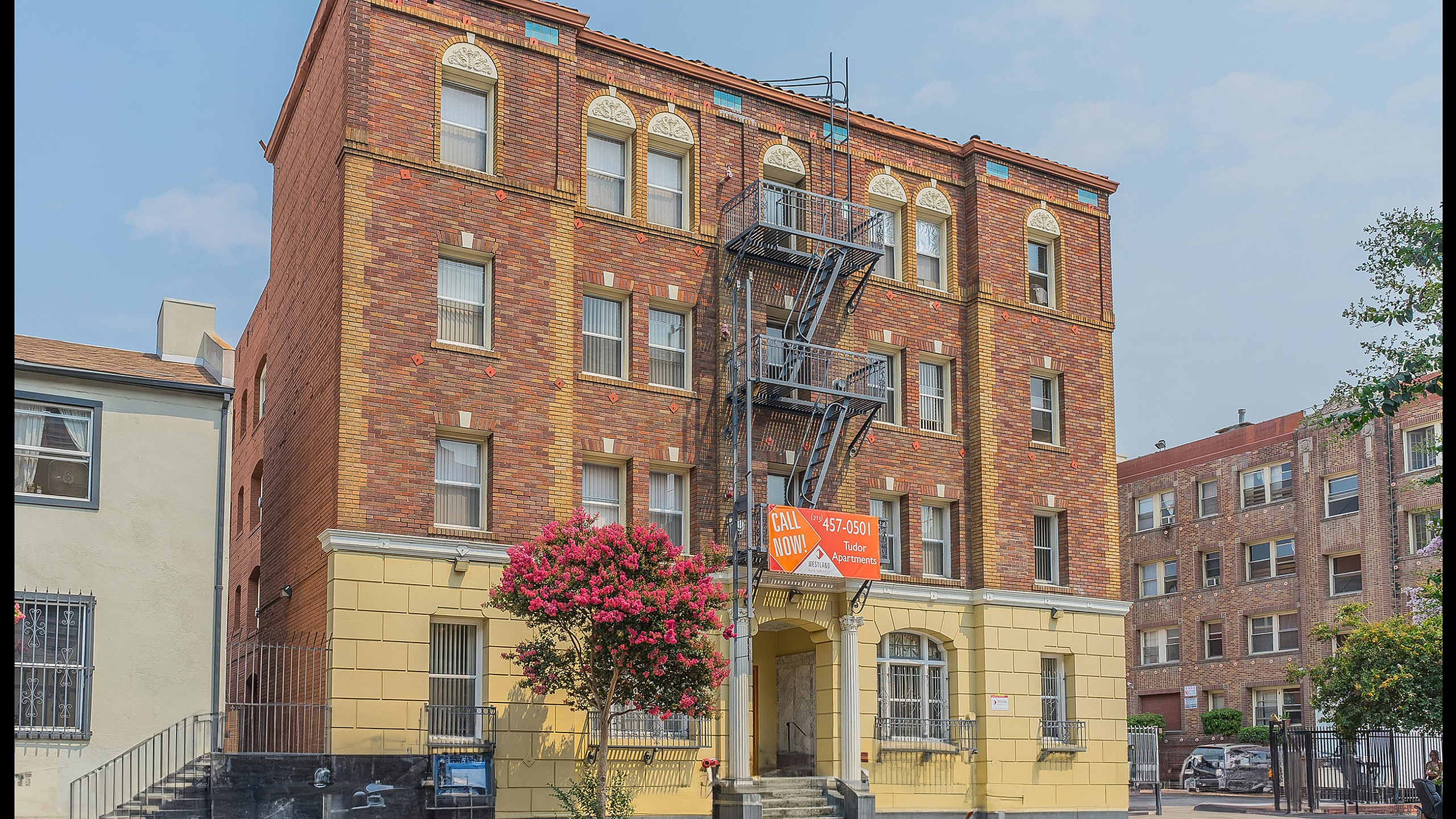 Charming brick building with classic architectural details, highlighting a vibrant facade and inviting entrance in an urban setting.