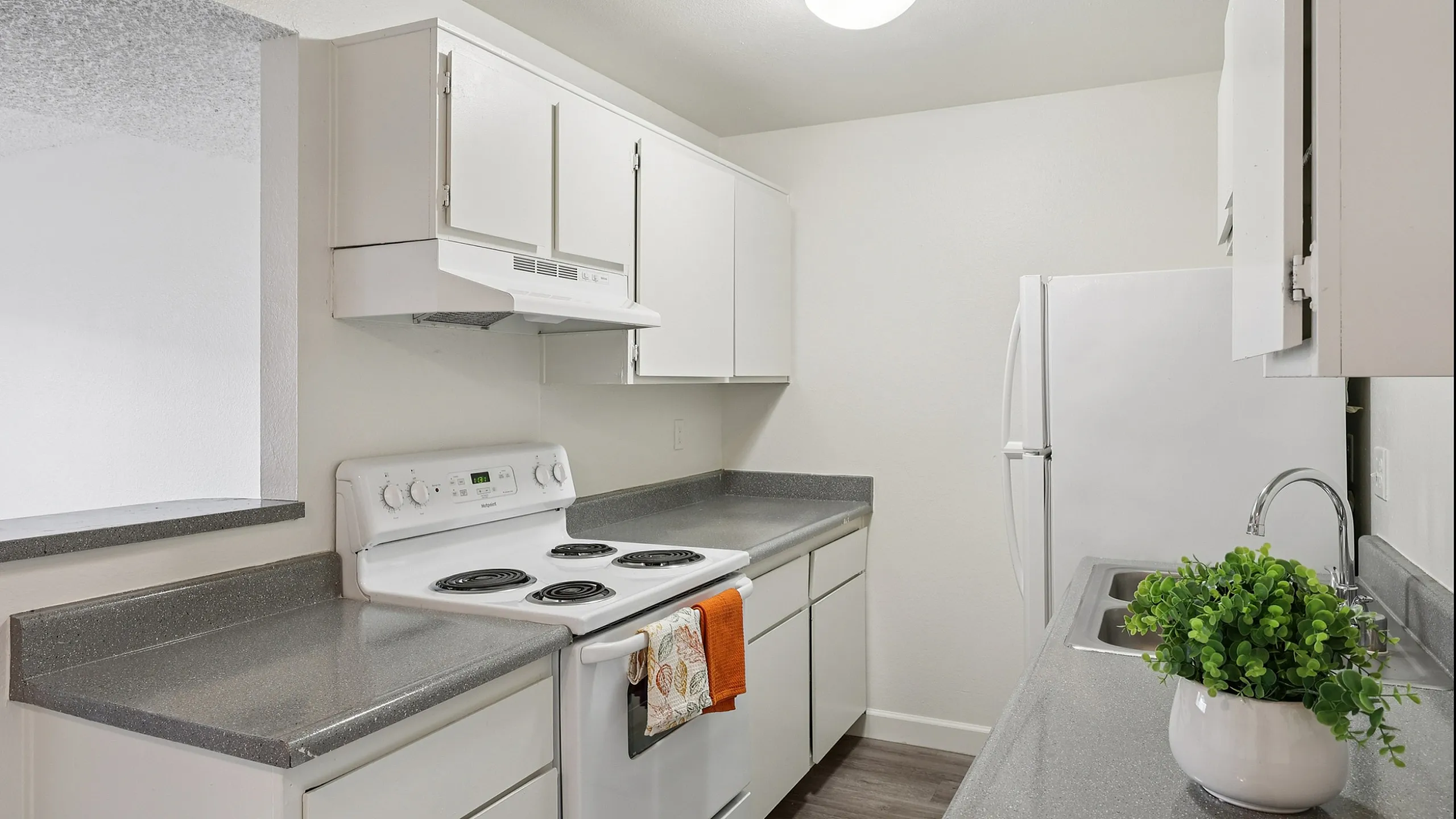 Modern kitchen with sleek countertops, white cabinetry, and stylish decor.