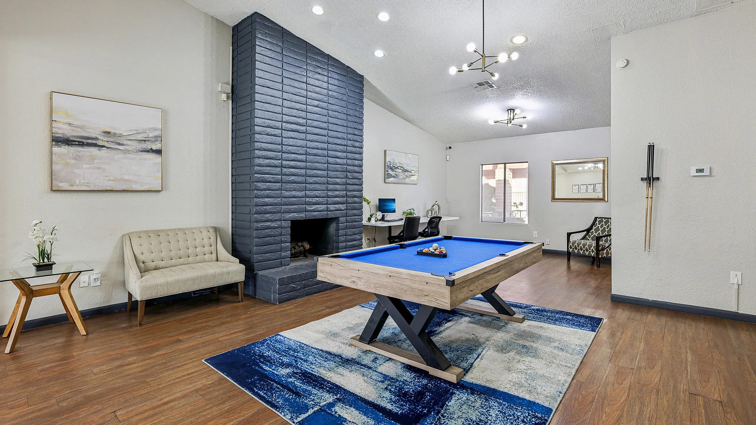 Chic and modern lounge area with a sleek pool table, cozy fireplace, and stylish seating, perfect for social gatherings.
