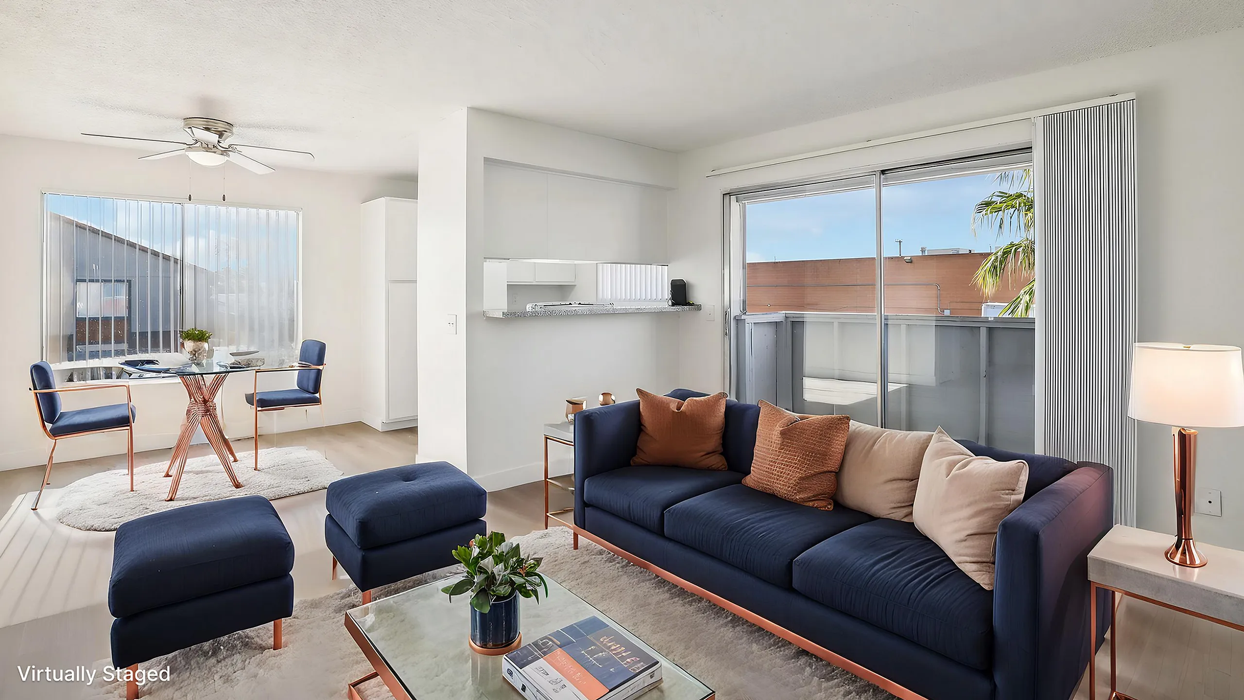 Bright and modern living space with a chic navy sofa, stylish dining area, and expansive balcony view, showcasing a perfect blend of comfort and elegance.