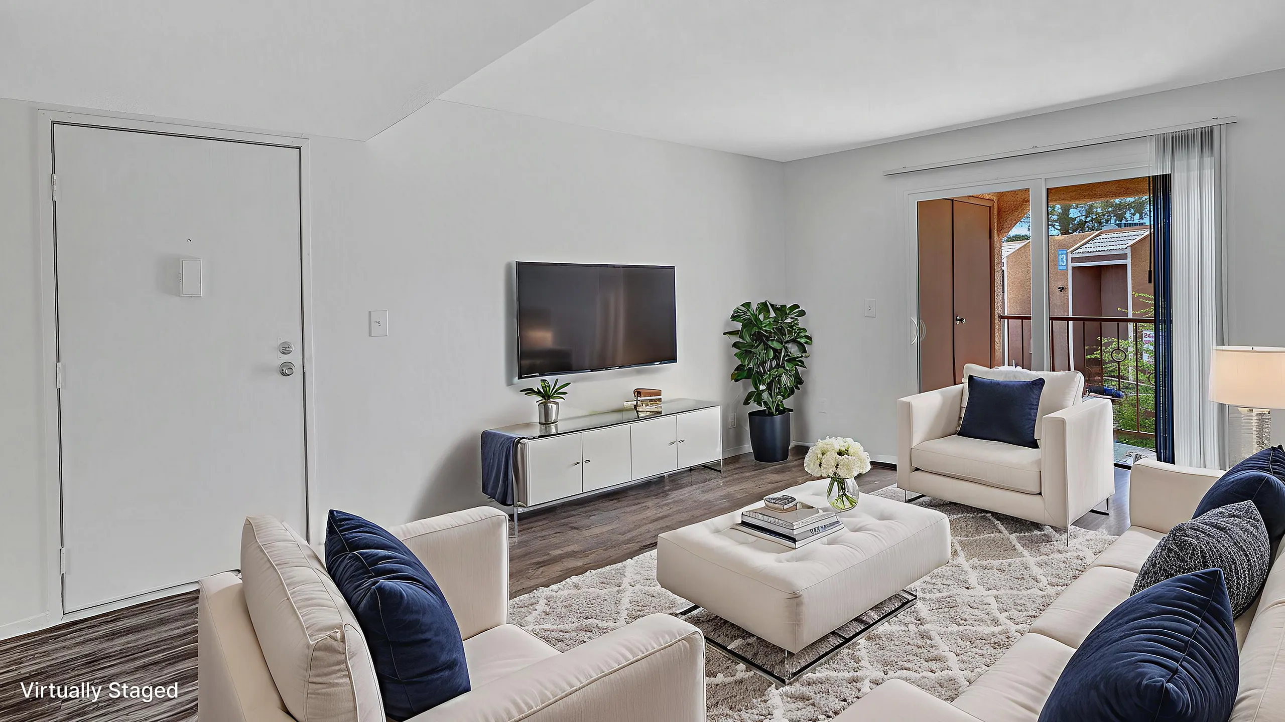 Bright, elegant living room featuring modern decor, plush seating, and abundant natural light from a sliding glass door opening to a cozy balcony.