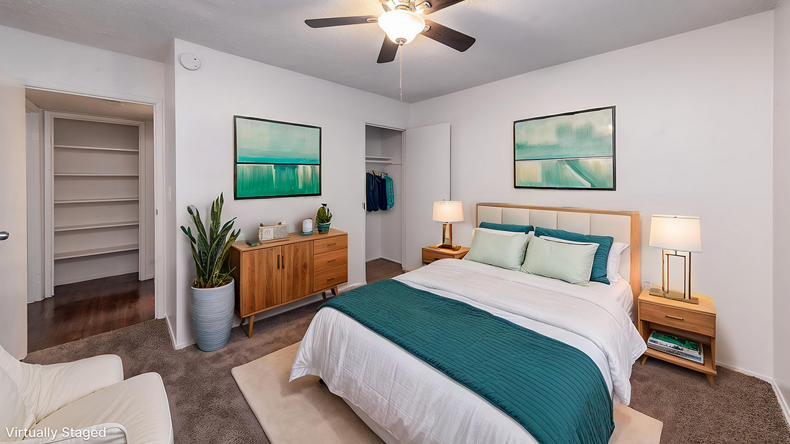 Chic bedroom design featuring a comfortable bed with teal accents, modern ceiling fan, stylish wooden furniture, and inviting decor with soft lighting.