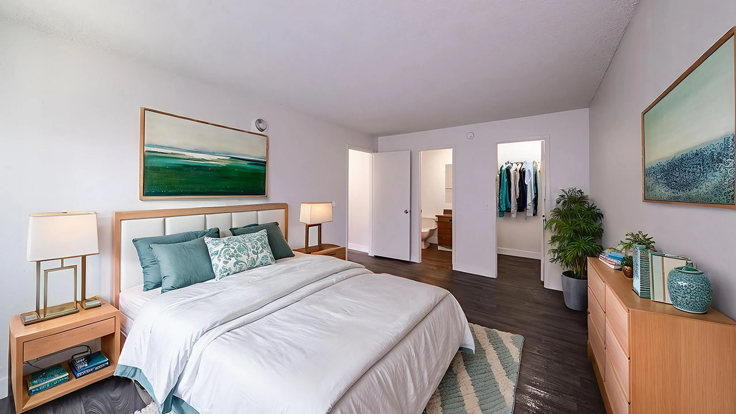 Elegant bedroom with stylish decor, featuring a cozy bed, modern artwork, and a walk-in closet.
