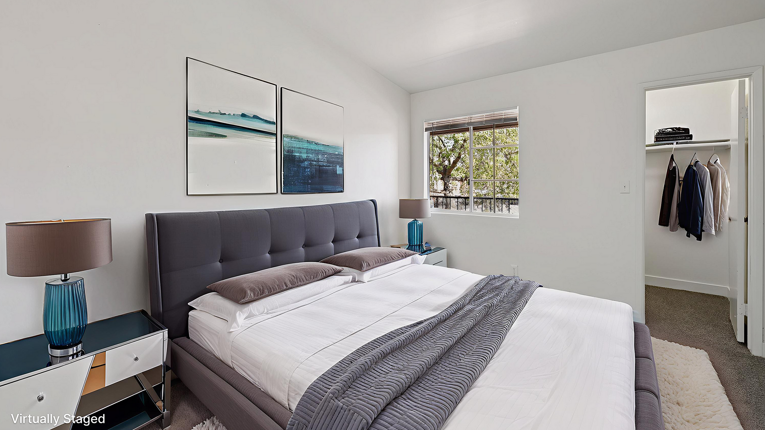 Chic bedroom with elegant decor, plush bed, and a view through a sunlit window reflecting modern luxury.
