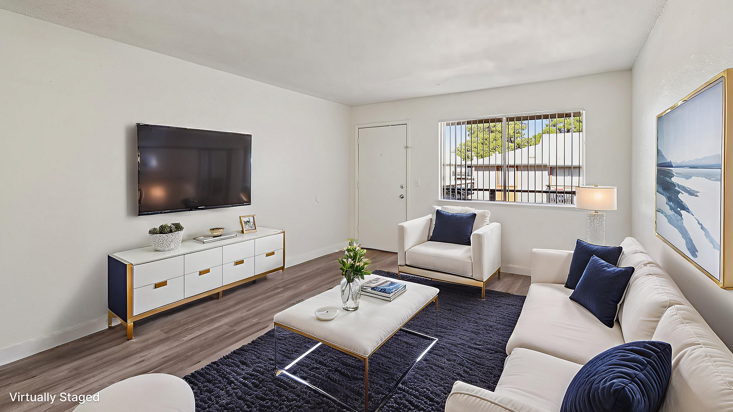 Bright and modern living room with sleek decor, featuring a wall-mounted TV, stylish couch, and elegant rug, basking in natural light from a large window.