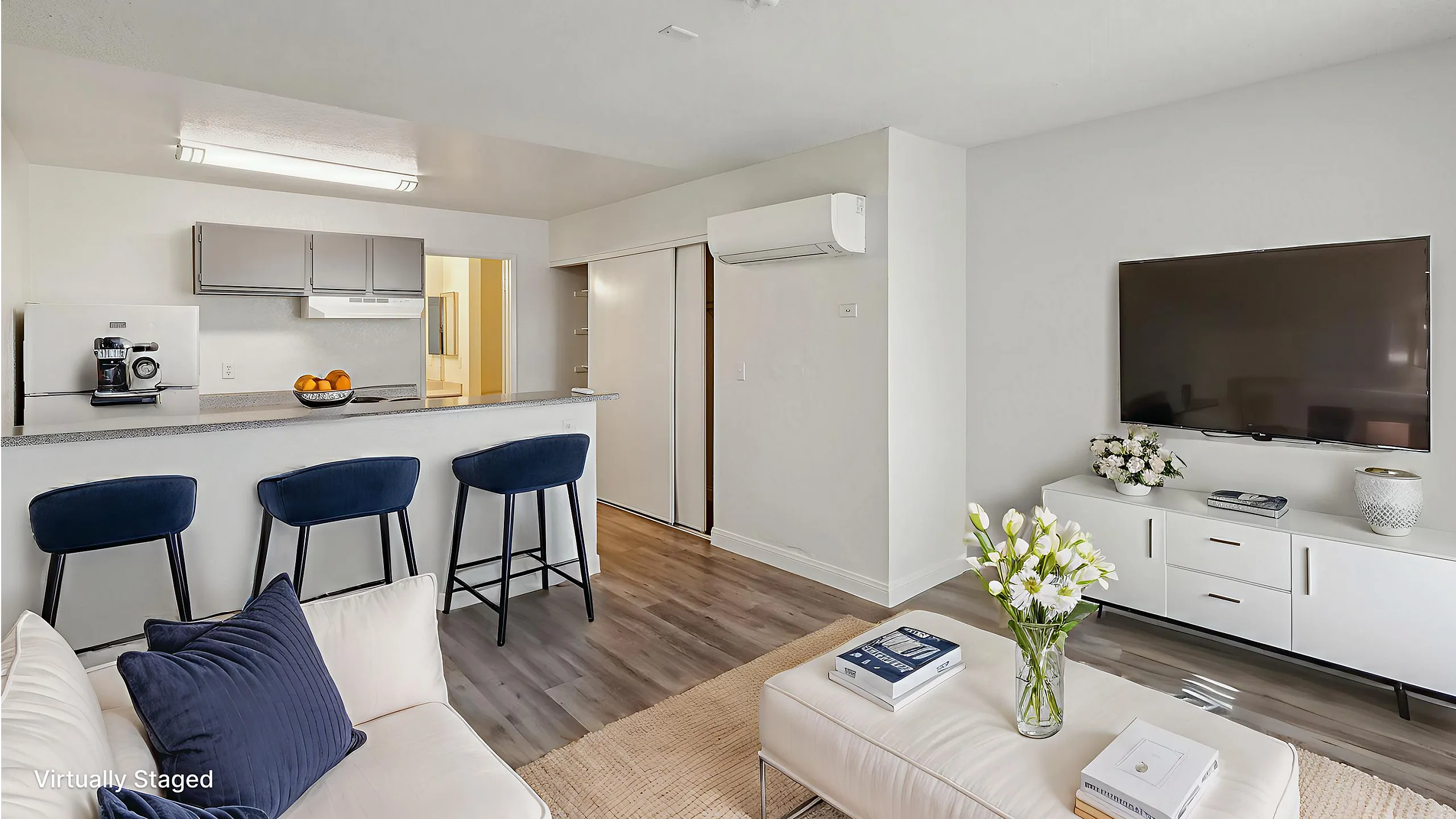 Virtually staged modern living room with stylish bar seating, sleek kitchen area, and elegant decor, creating a cozy and inviting atmosphere.