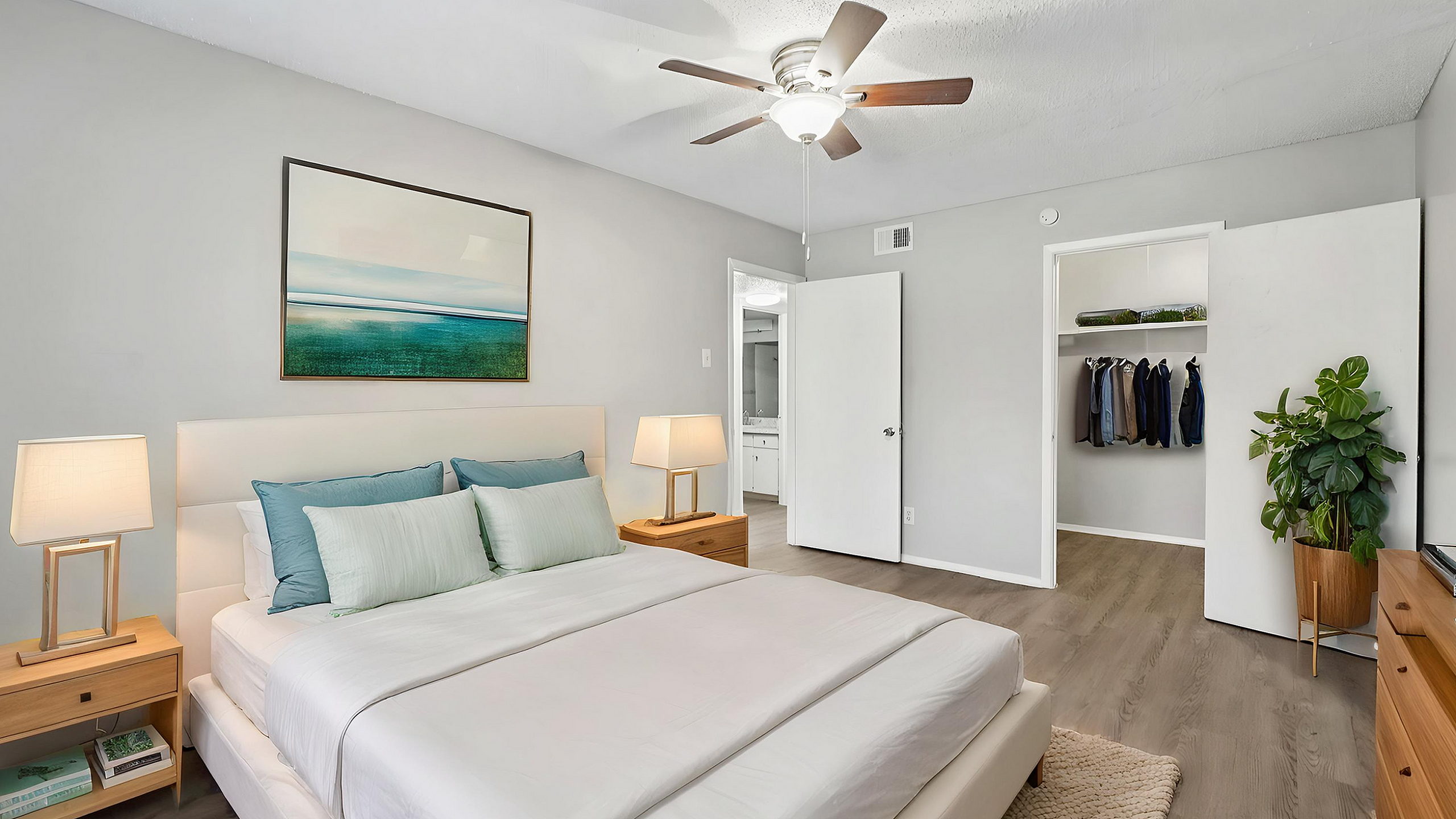 Inviting bedroom with modern decor, featuring a cozy bed, stylish ceiling fan, and spacious closet, enhanced by natural light.