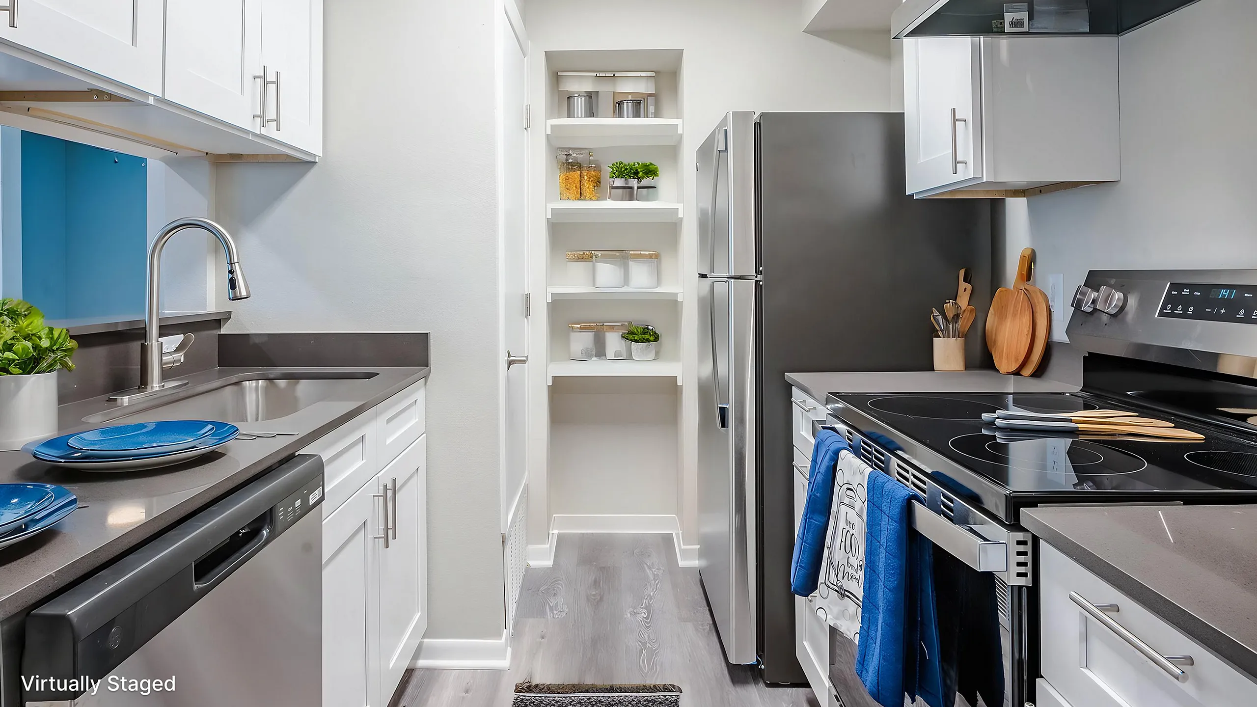 Sleek modern kitchen featuring stainless steel appliances, bright white cabinetry, and stylish open shelving with decorative touches.