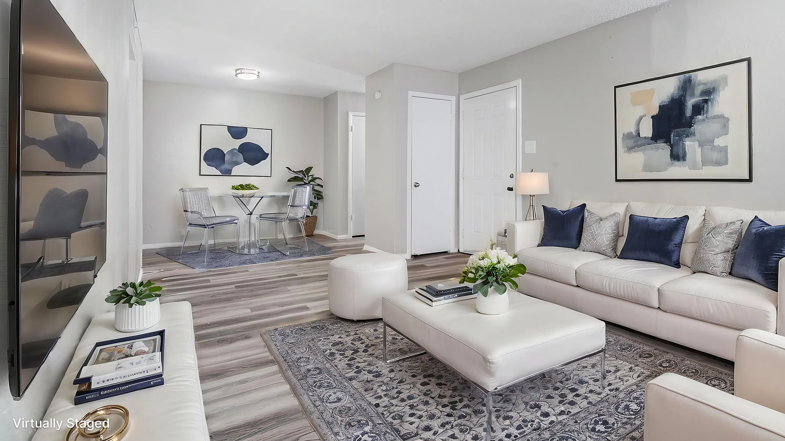 Elegantly staged modern living room featuring a sleek white sofa, cozy ottoman, and tasteful abstract artwork. Bright dining area with stylish chairs and a contemporary table, creating an inviting space for relaxation and entertainment.