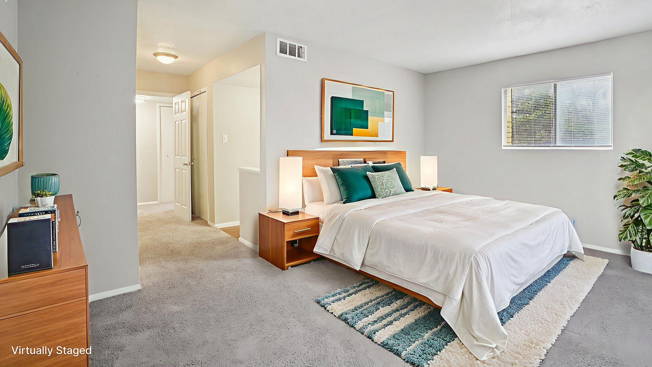 Virtually staged bedroom showcasing a stylish bed, modern lamps, and vibrant artwork, with abundant natural light and a plush rug.